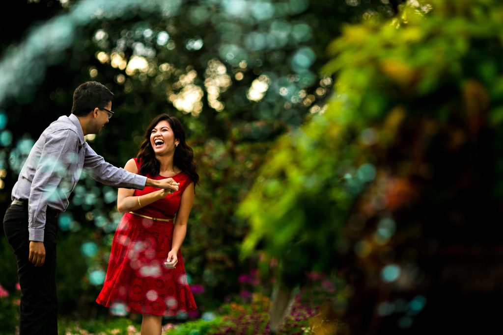 A couple dancing in a park and laughing during an engagement session in Winnipeg