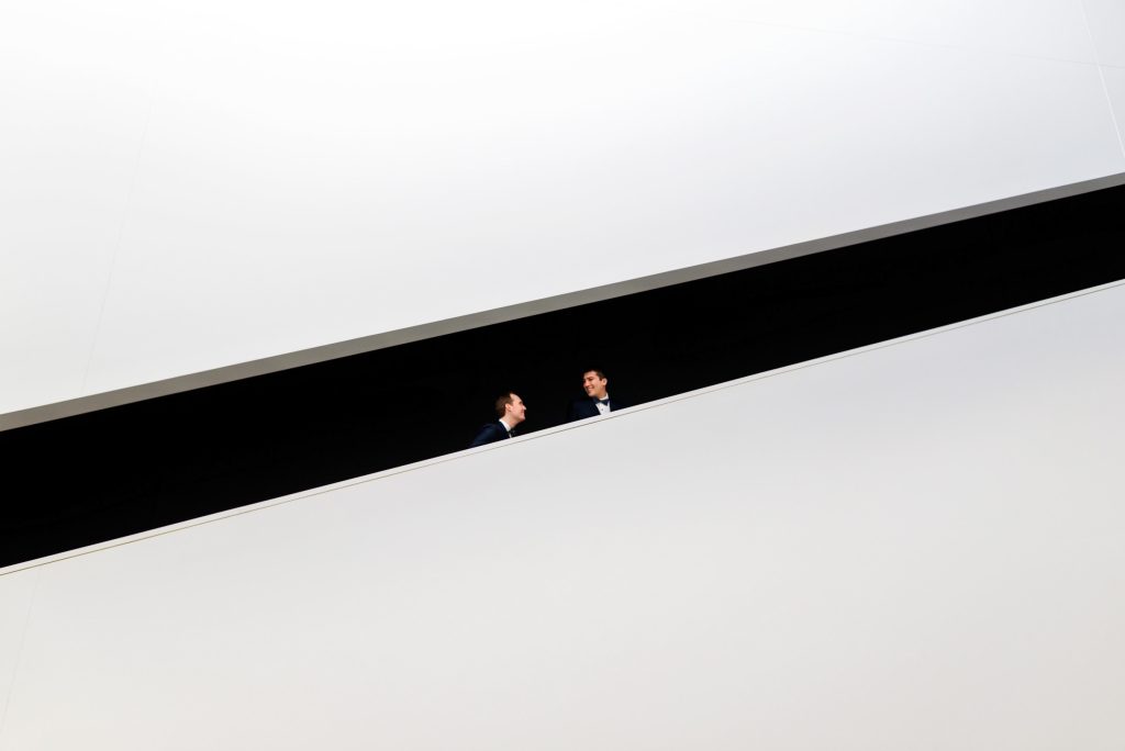 a gay Groom and groom walking Upstairs on their wedding day