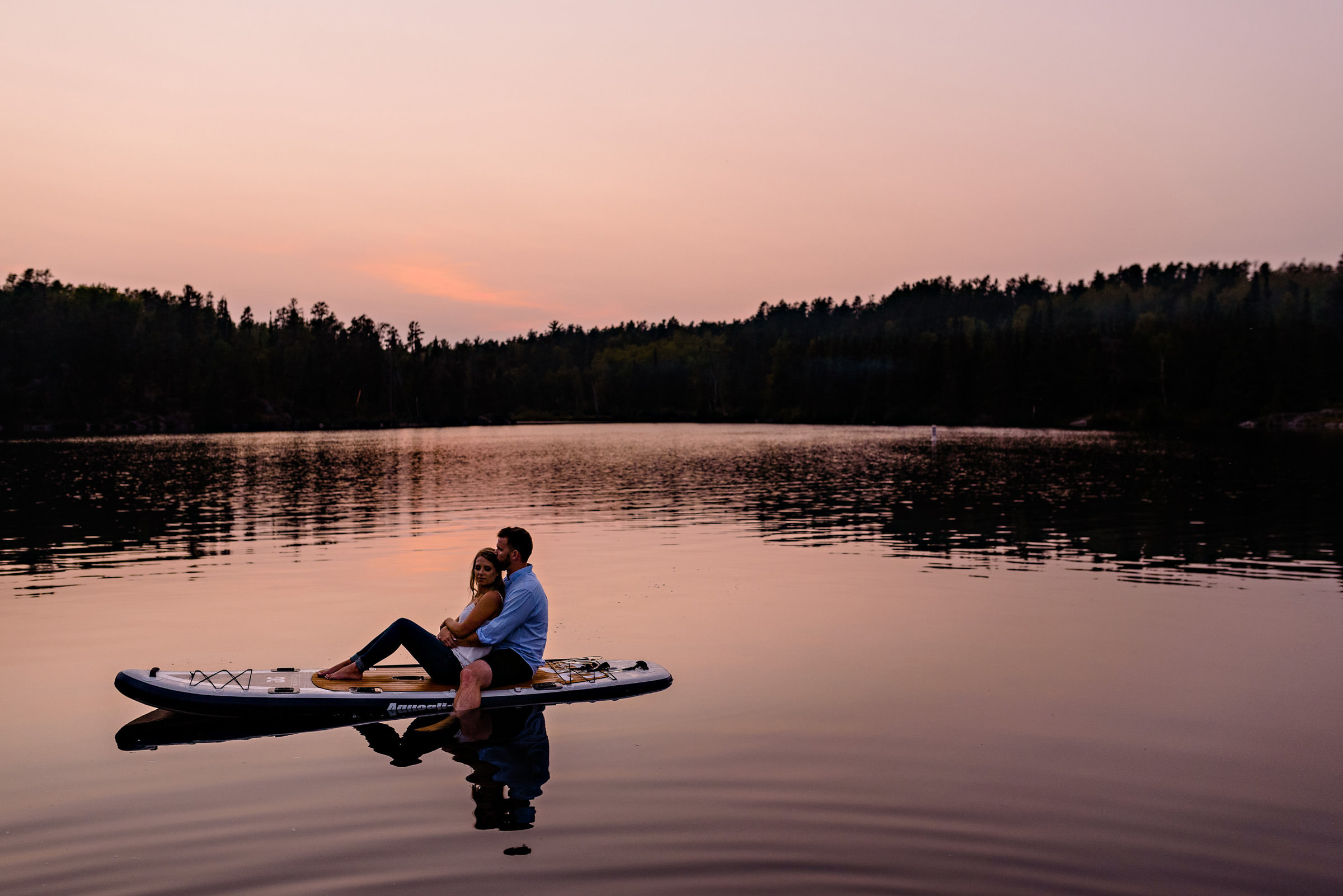And engaged couple sitting on a quiet lake on a paddleboard in Winnipeg Manitoba