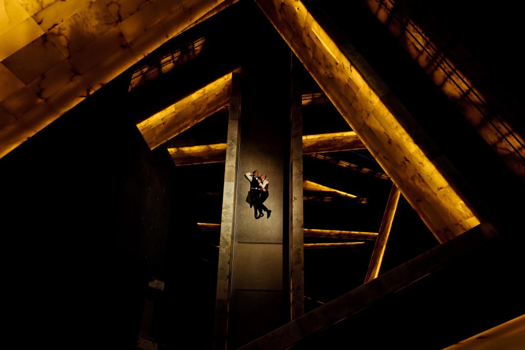 A gay wedding cuddling on the ground in a beautiful walkway at the Canadian museum for human rights