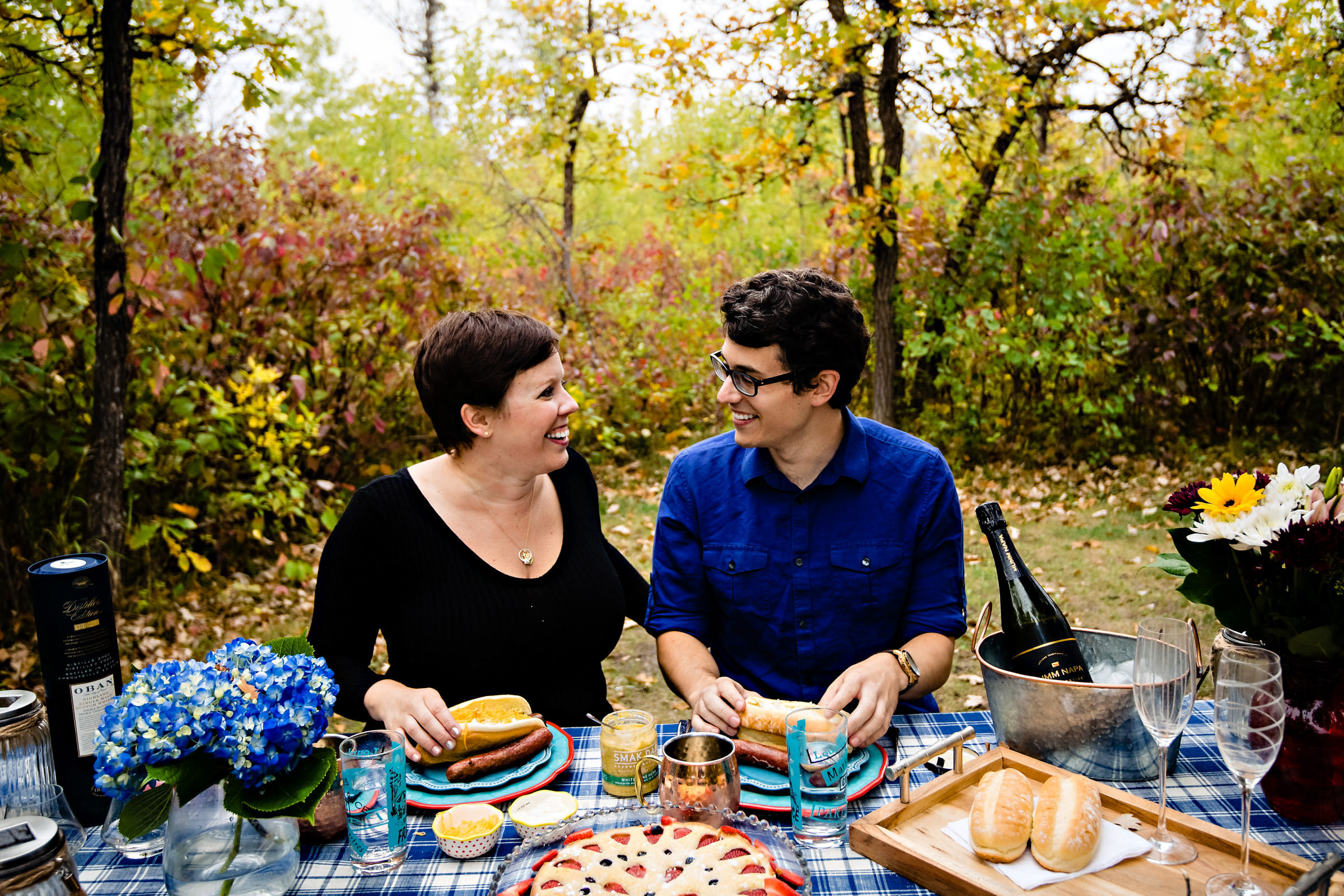 And engaged couple, having fun at an engagement session, making hotdogs at birds Hill Park in Manitoba