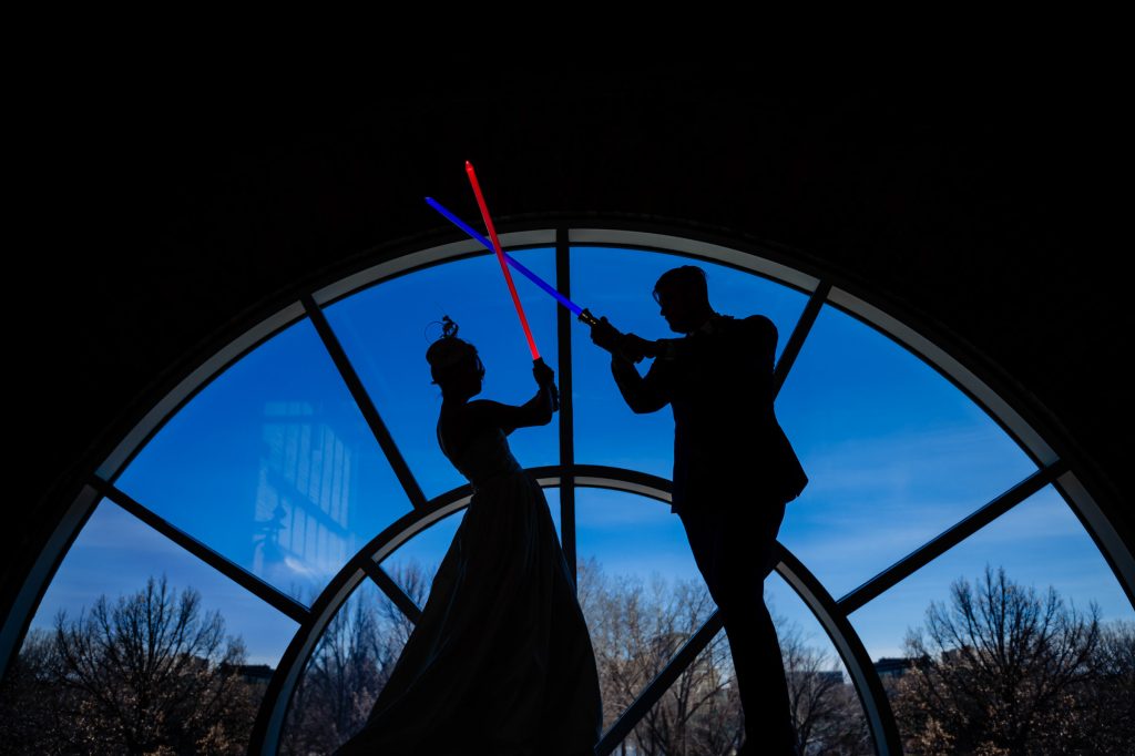 Star Wars themed wedding, photo of a bride and groom, fighting with light sabers