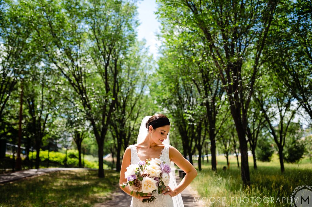 Bride posing in a pathway at the forks with her flower bouquet