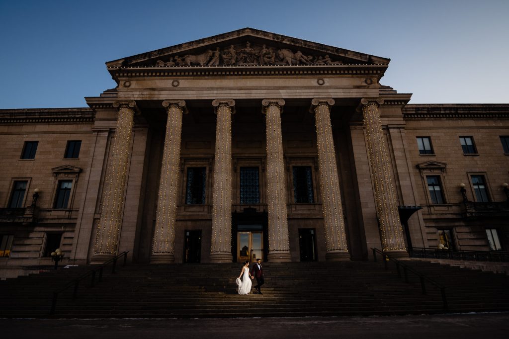 A riding room, walking down a staircase at dusk at the Manitoba legislative building