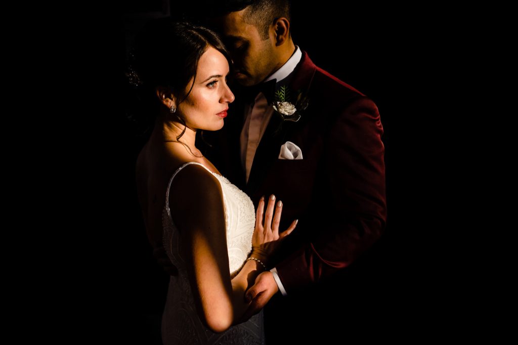 Add bride and groom in a romantic pose in darkness photograph inside Allure Studios in downtown Winnipeg