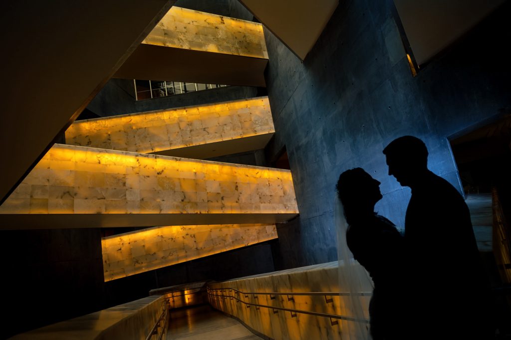 A silhouette of a bride and groom with glowing staircases in the Canadian museum for human rights