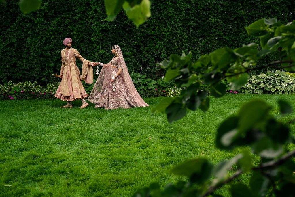 Bride and groom, holding hands and walking through botanical in Winnipeg Manitoba