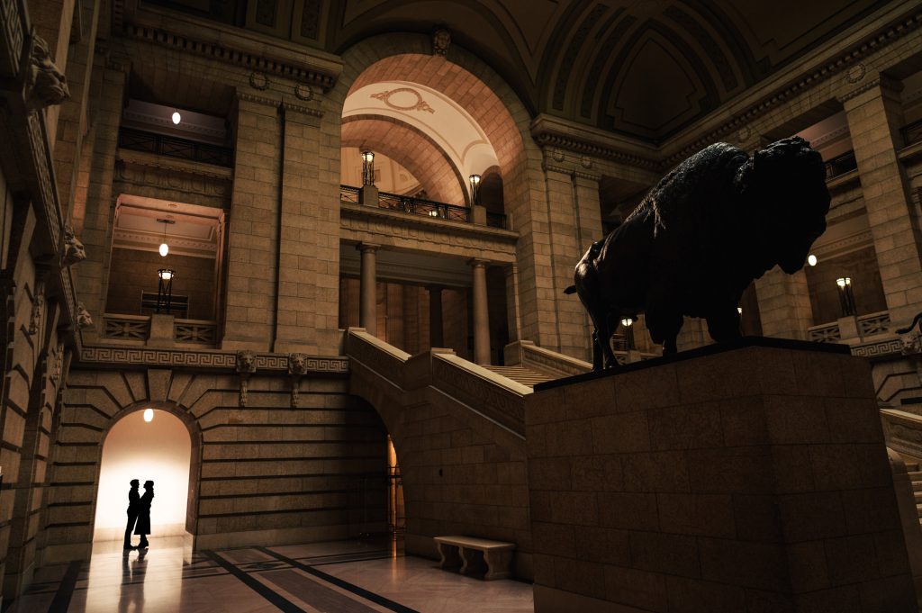 Silhouette of an engaged couple posing for a photo at the Winnipeg legislative building