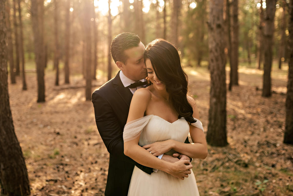 Our bride and groom, embracing for a wedding photo during sunset in Golden light in a forest in Winnipeg Manitoba