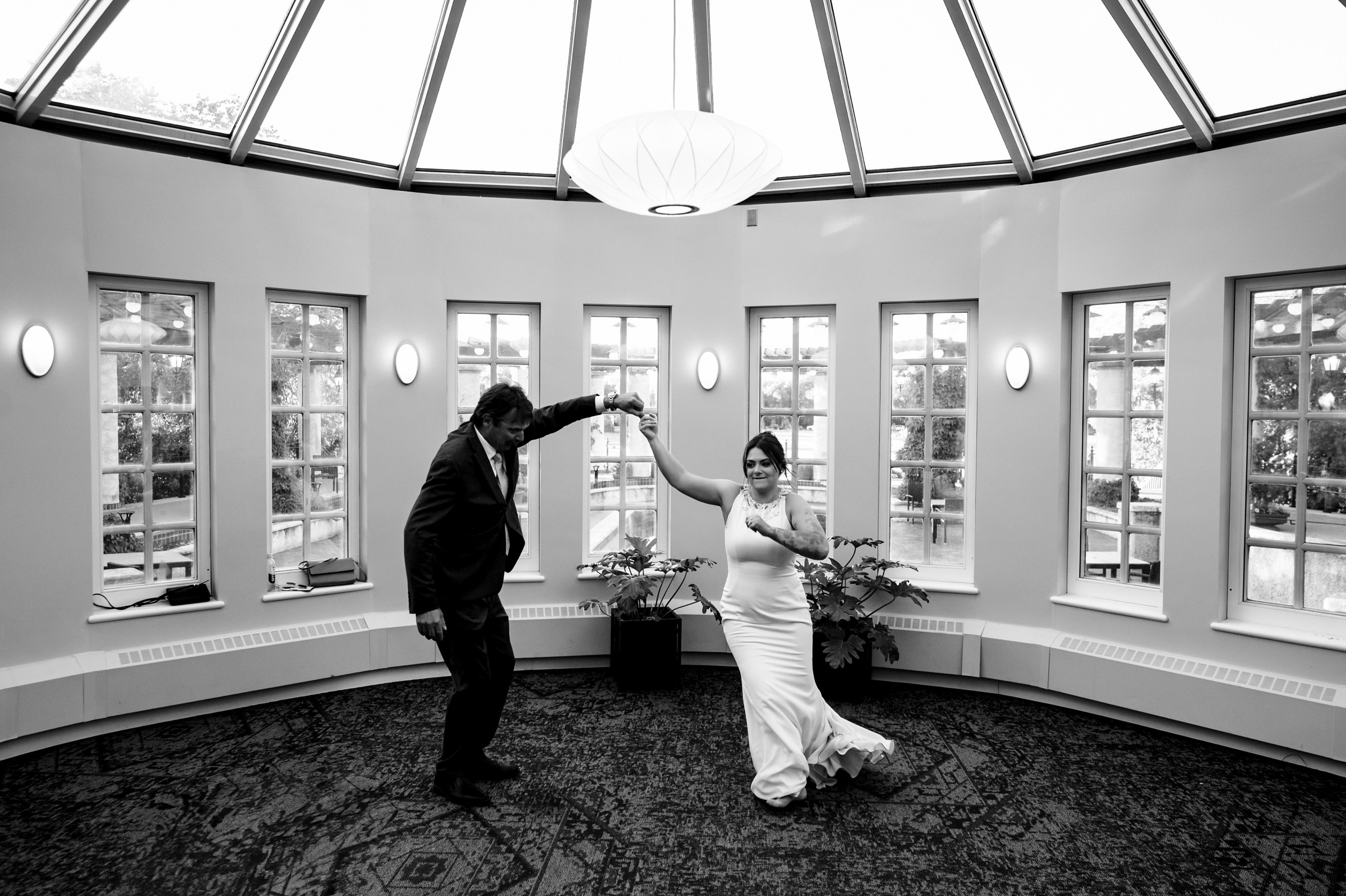 Couple dancing in a circular, glass-ceilinged room at a top Winnipeg wedding venue.