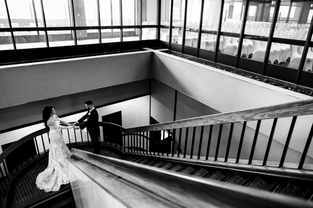 Bride and groom on a spiral staircase, black and white photo of fall wedding in Winnipeg.