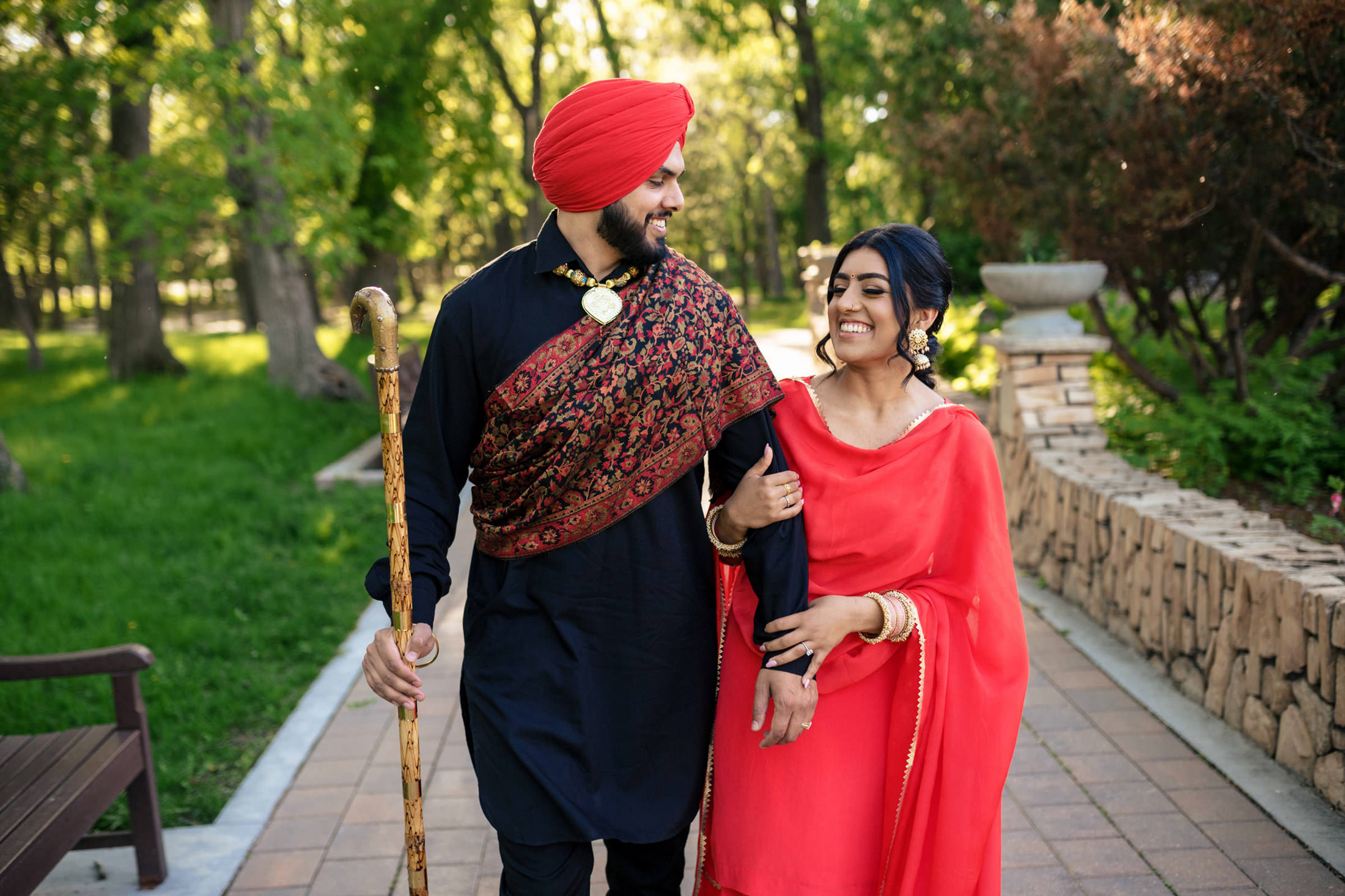 Couple in traditional attire walking together in a park.