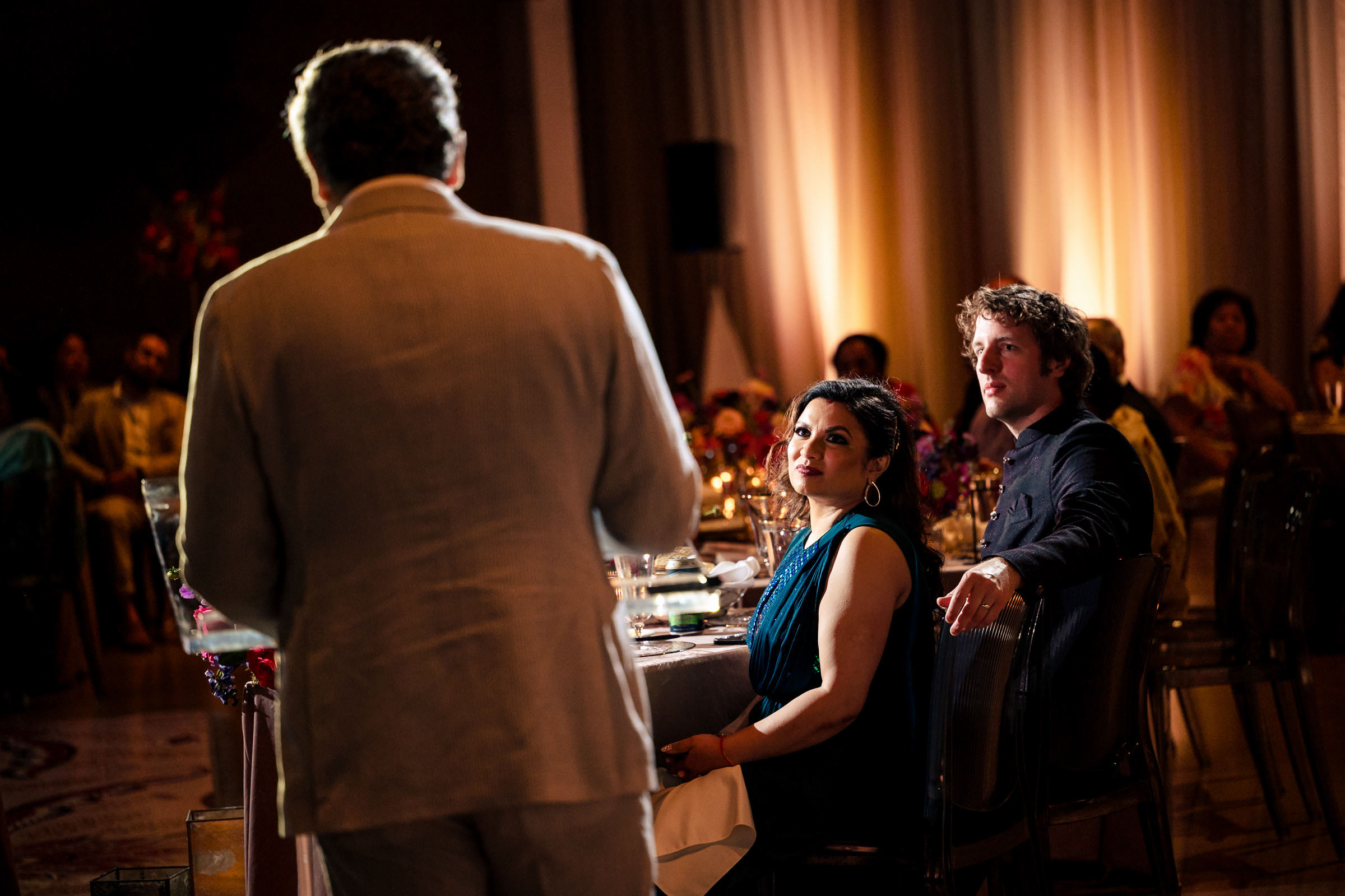 bride and groom listen to speeches at their reception at the Canadian Museum for Human Rights in Winnipeg