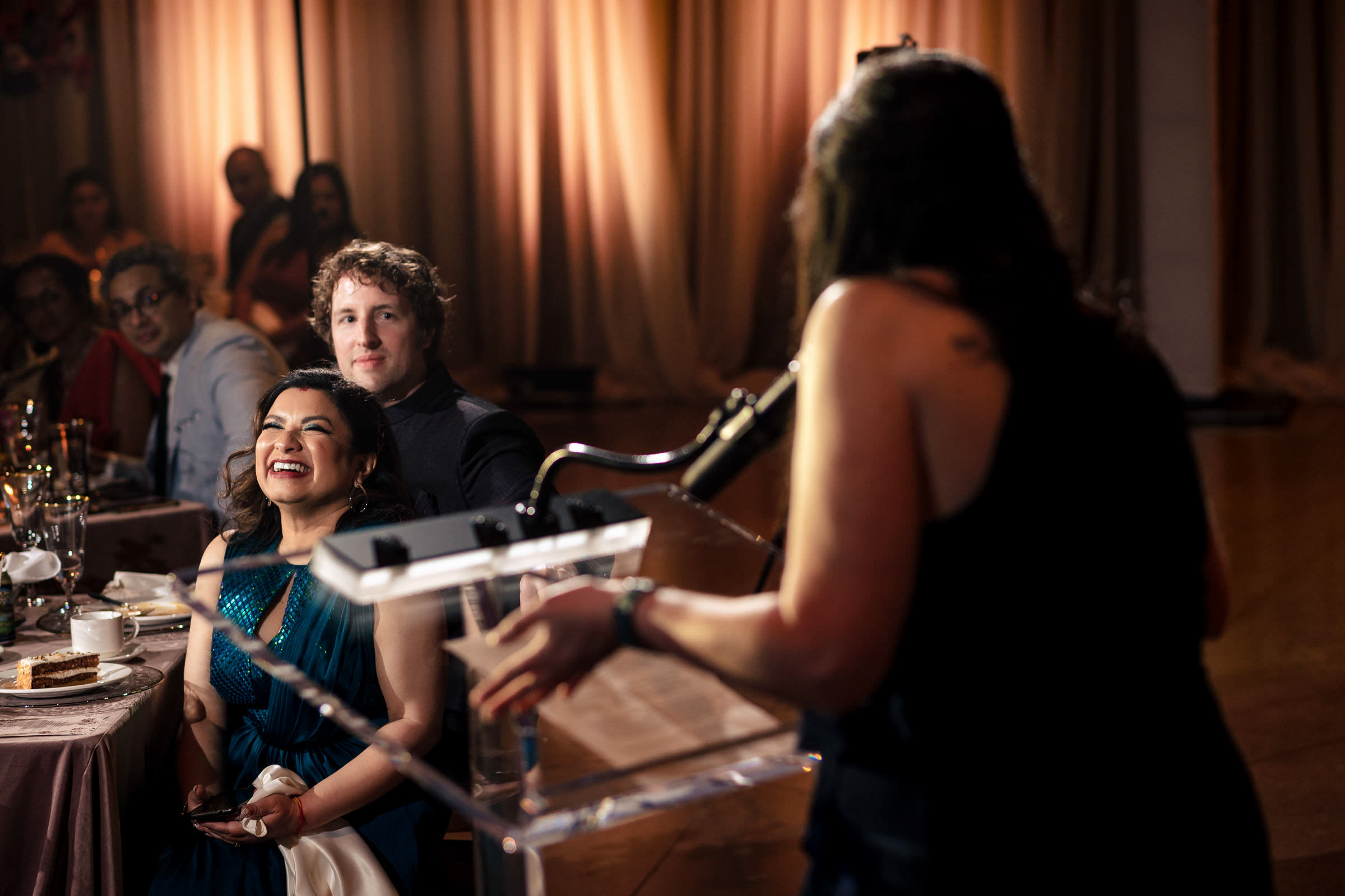Person speaking at a podium to a seated bride and others at a Winnipeg wedding event.