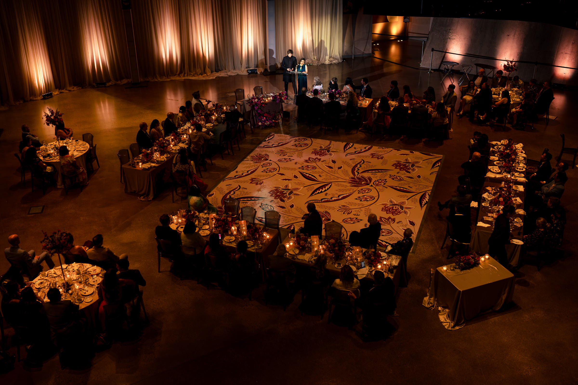 Aerial view of an elegant Winnipeg wedding with round tables and a patterned square carpet.