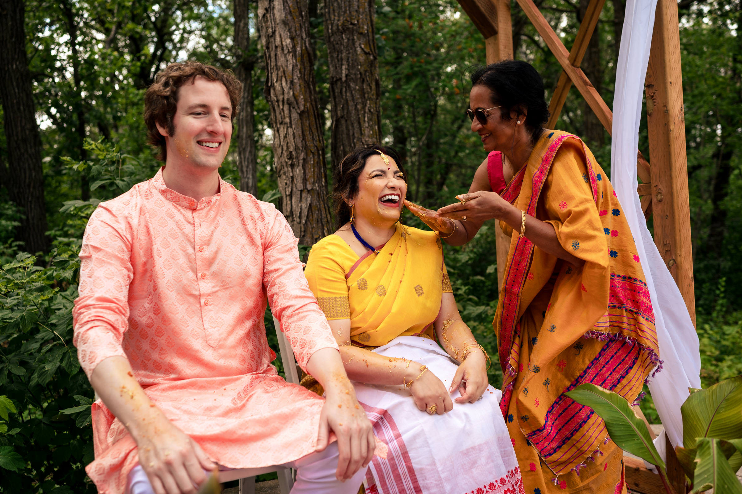 Three people in colorful attire enjoying a festive outdoor Winnipeg wedding.
