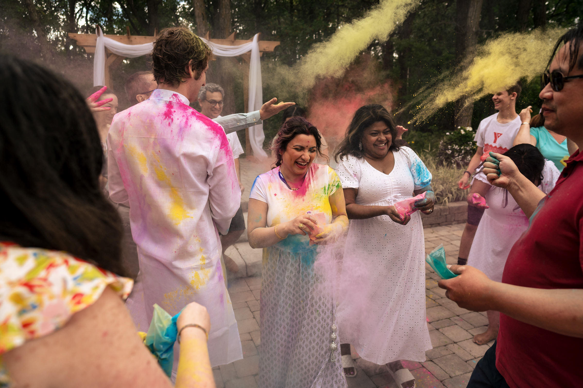 People celebrate Holi outdoors, colorful powders and smiles like a joyful Winnipeg wedding.