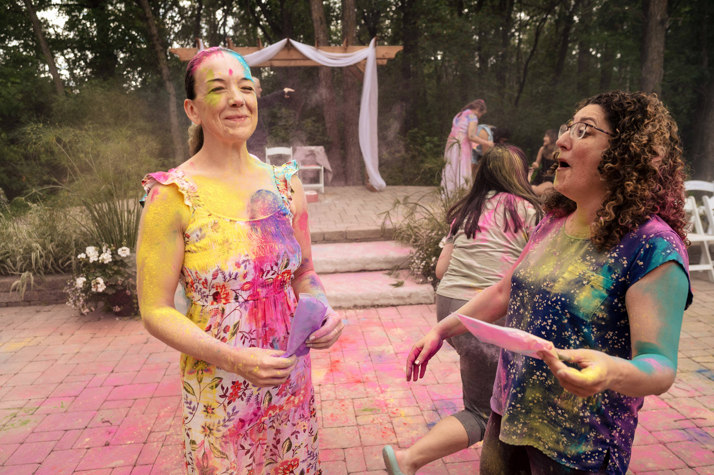 Two people covered in colorful powder at an outdoor celebration, like a vibrant Winnipeg wedding.