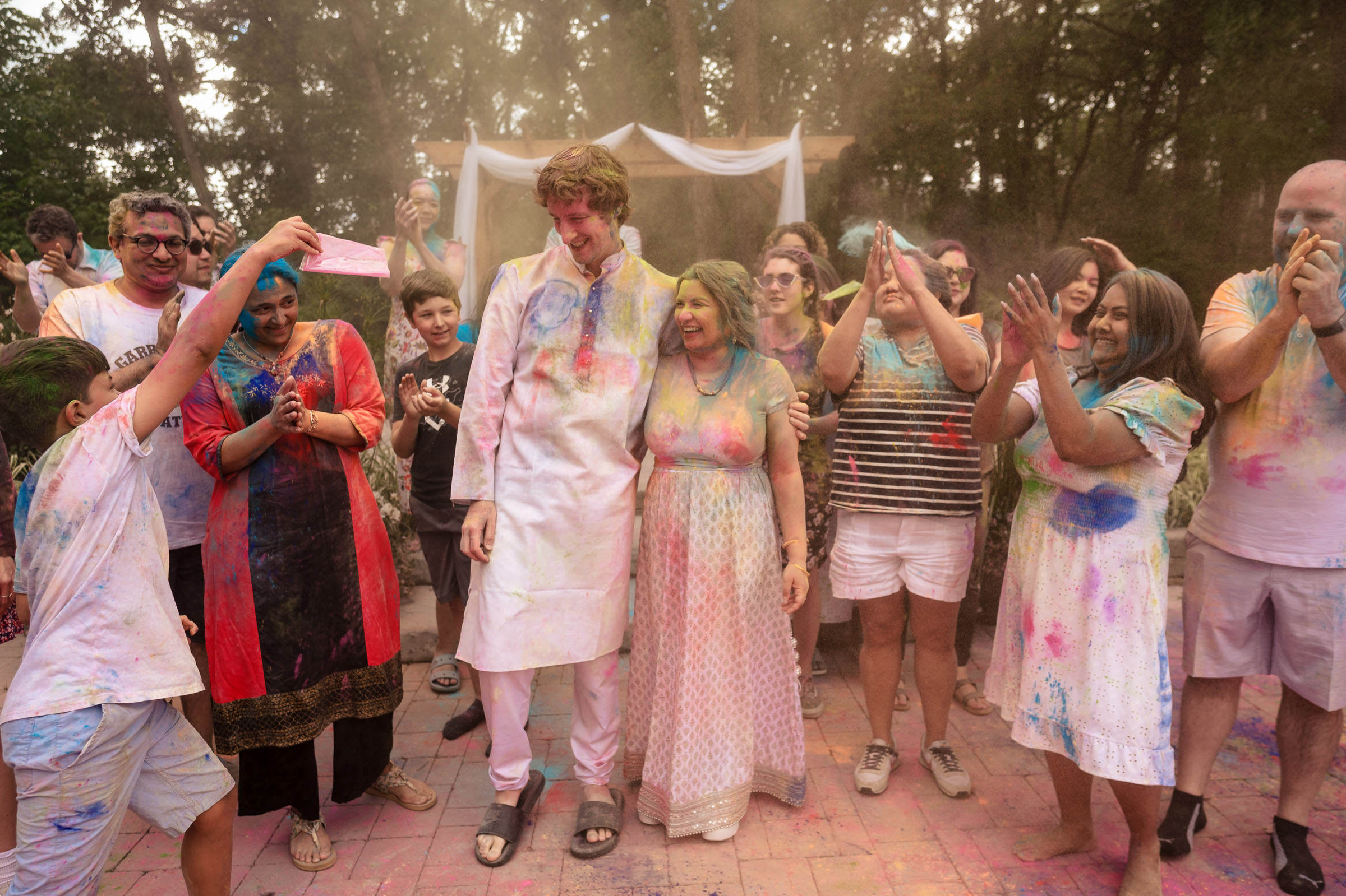 People celebrating Holi with colorful powders at an outdoor gathering in Winnipeg.