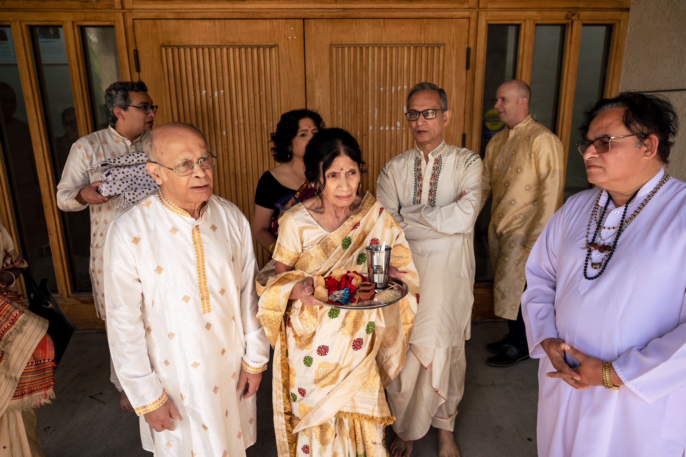A group in traditional attire at a Winnipeg wedding, with a woman holding a decorative tray.