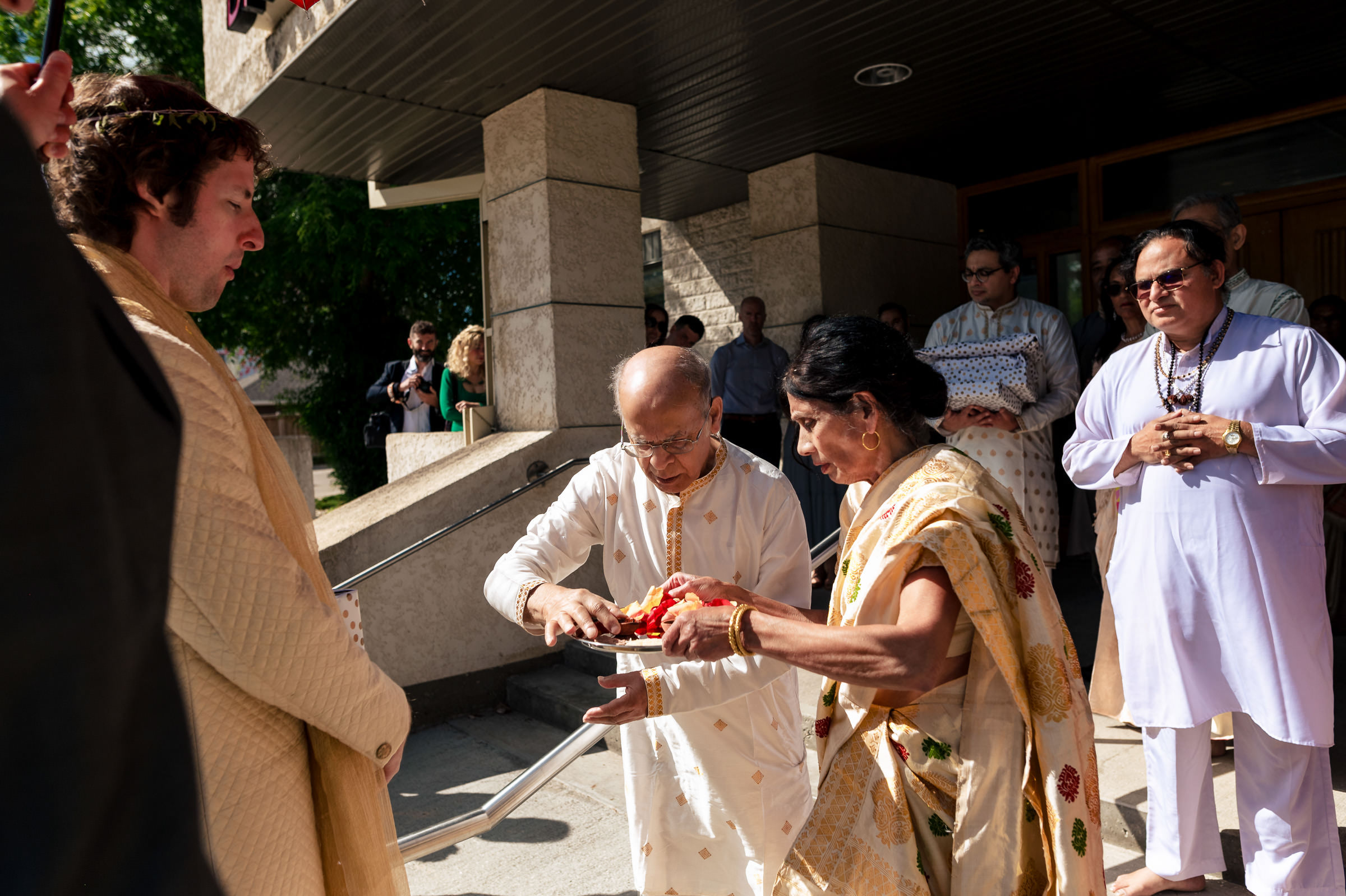 People performing a Winnipeg wedding ritual outside on a sunny day.