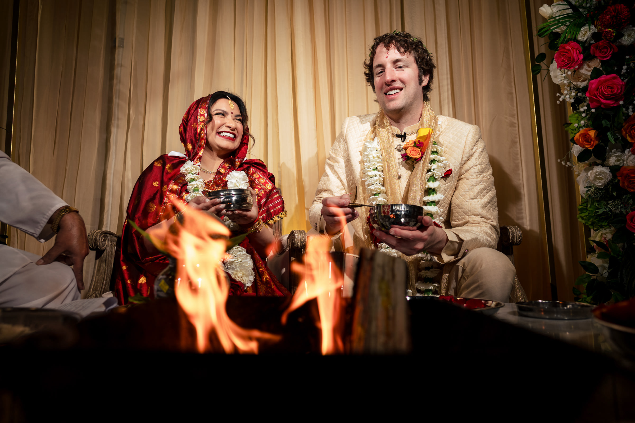 Couple in traditional attire join a ceremony before a fire at a Winnipeg wedding.