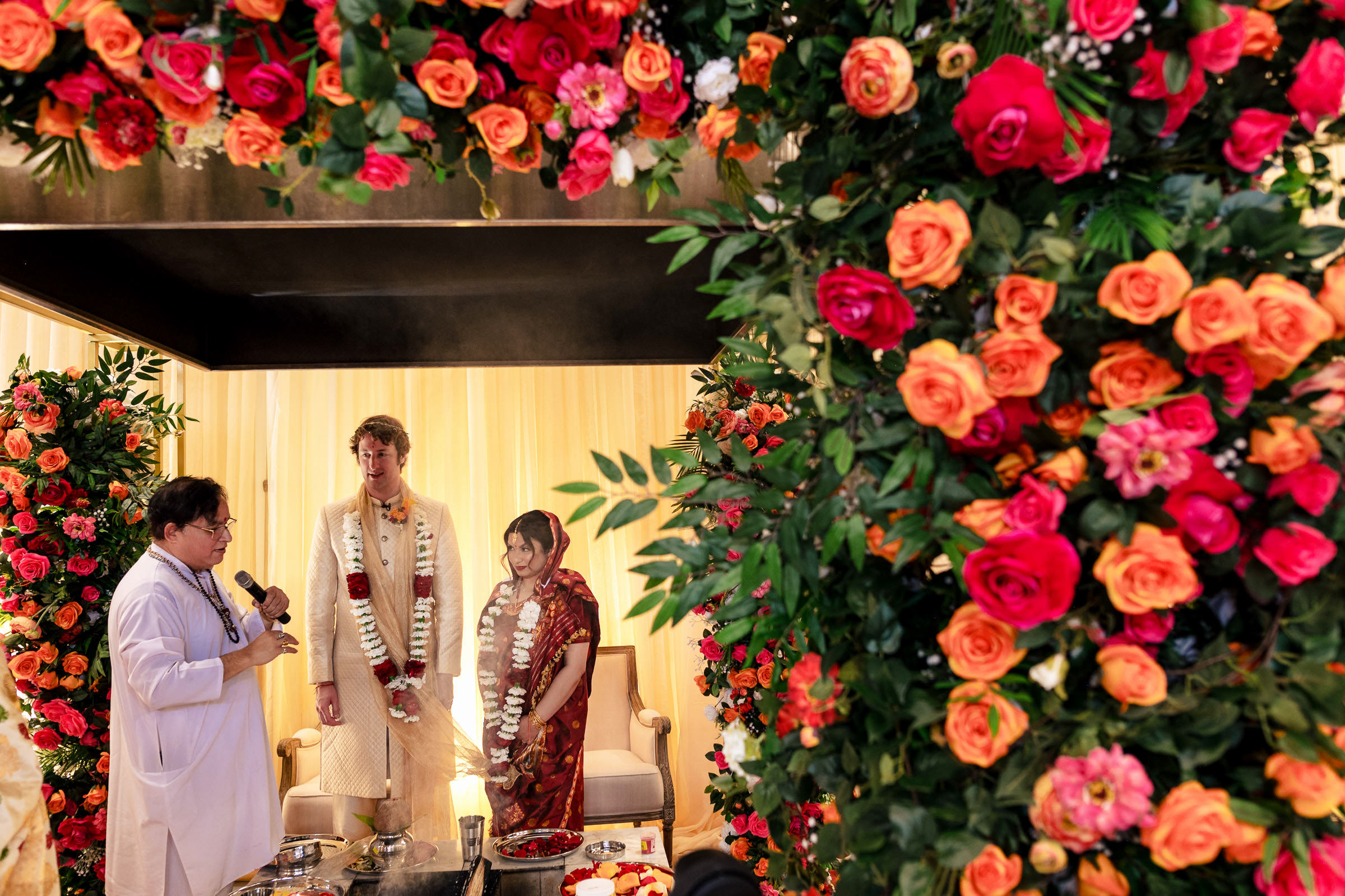 A couple stands at a Winnipeg wedding, surrounded by vibrant floral arrangements.