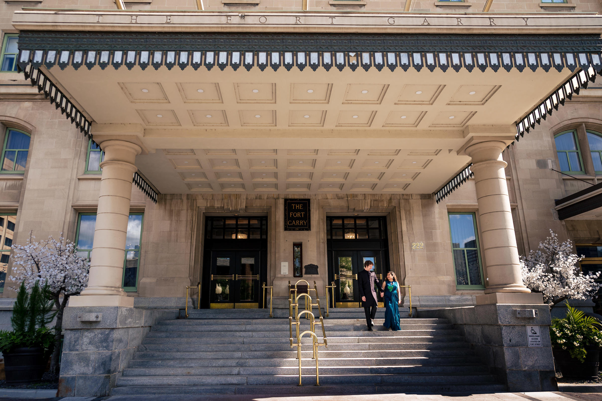Wedding guests walking down steps of the Fort Garry Hotel entrance in Winnipeg.