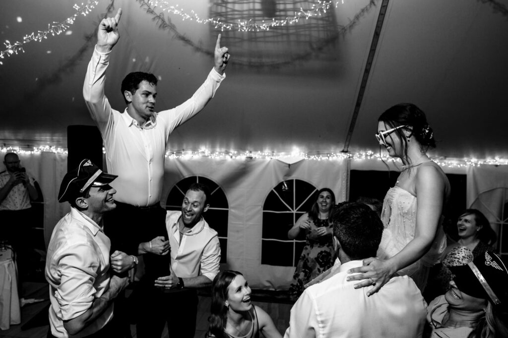 People celebrating at a wedding, with fairy lights and joyful expressions.