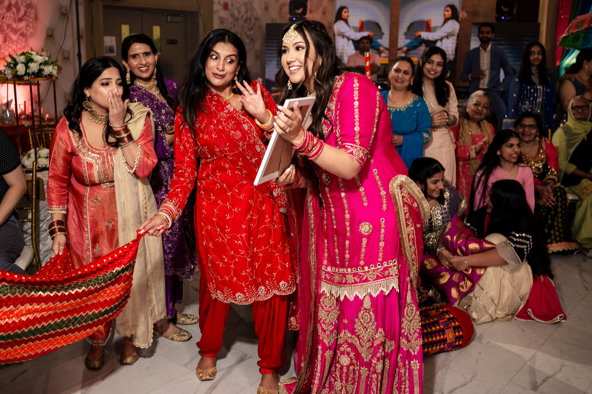 A group of people in colorful traditional attire celebrating indoors.