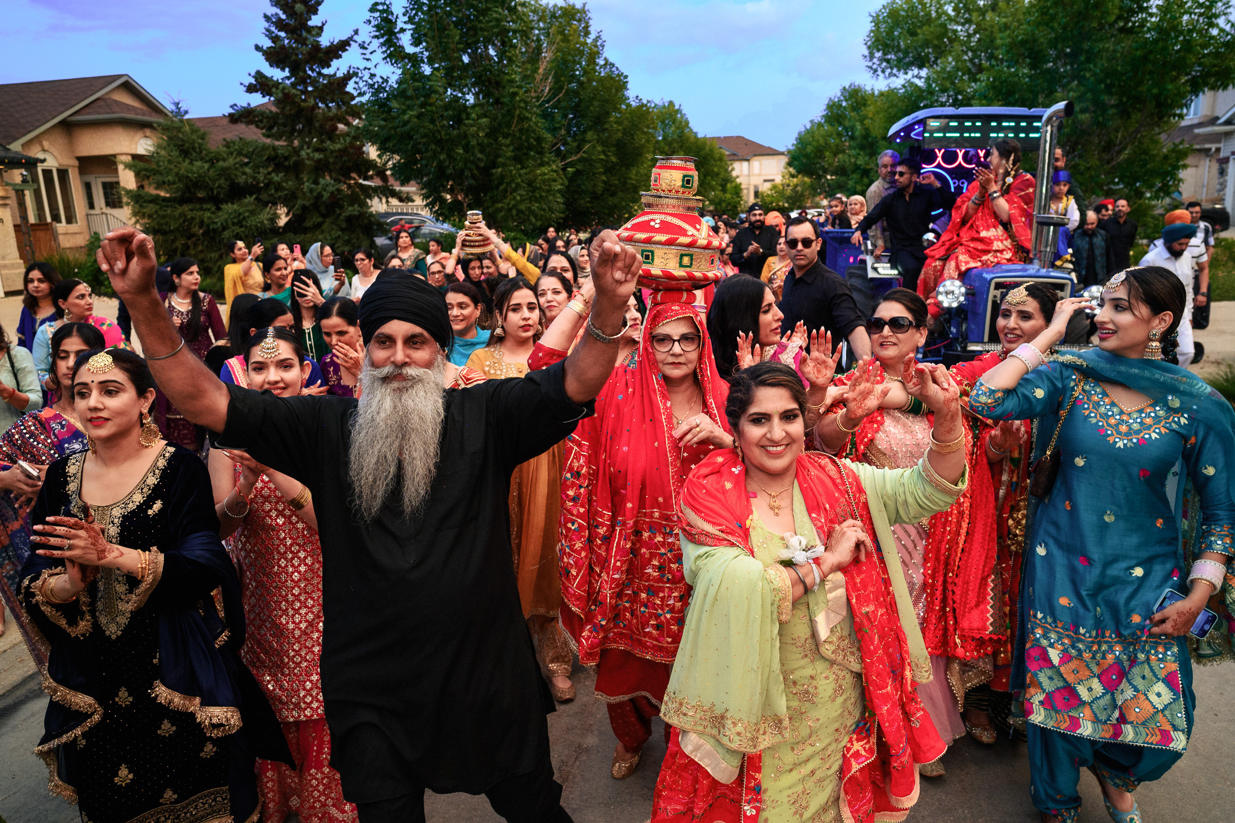 A group of people in colorful attire dancing at an outdoor event.