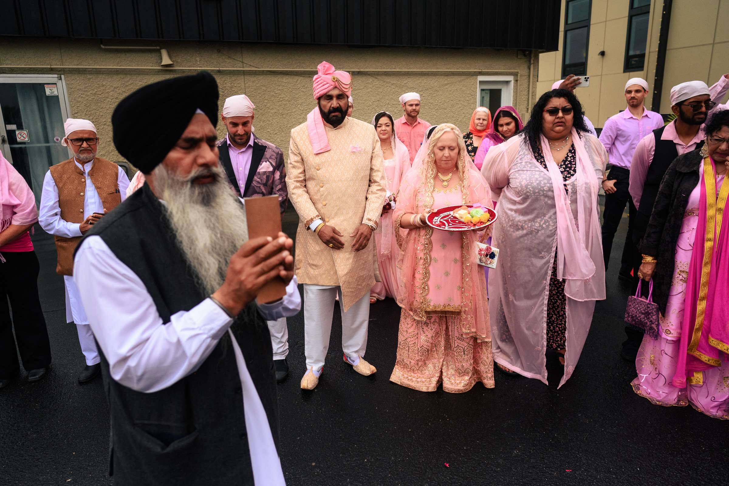 A group of people in traditional attire participate in an outdoor ceremony.