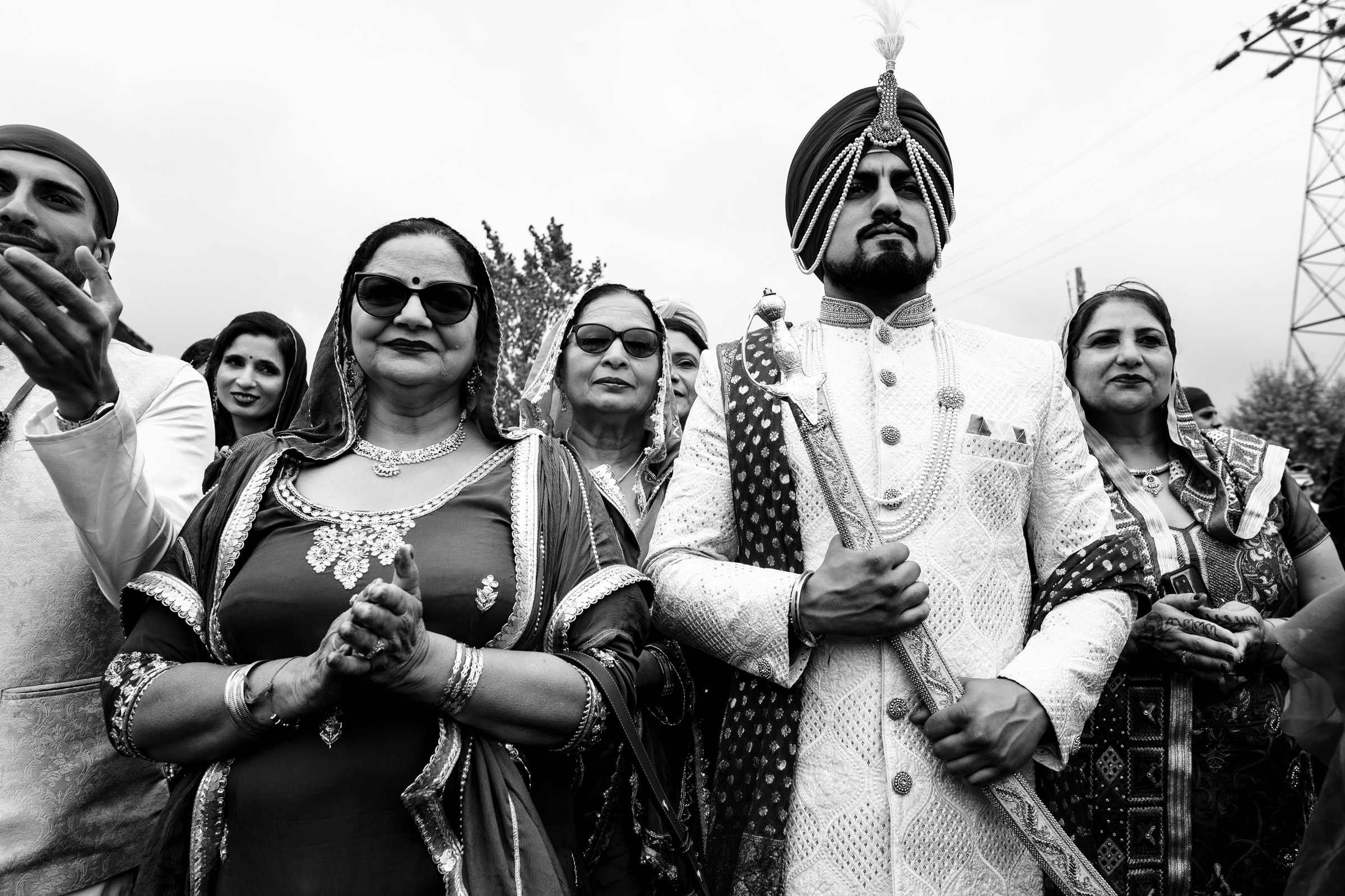 A groom stands with women in traditional attire during a ceremony.