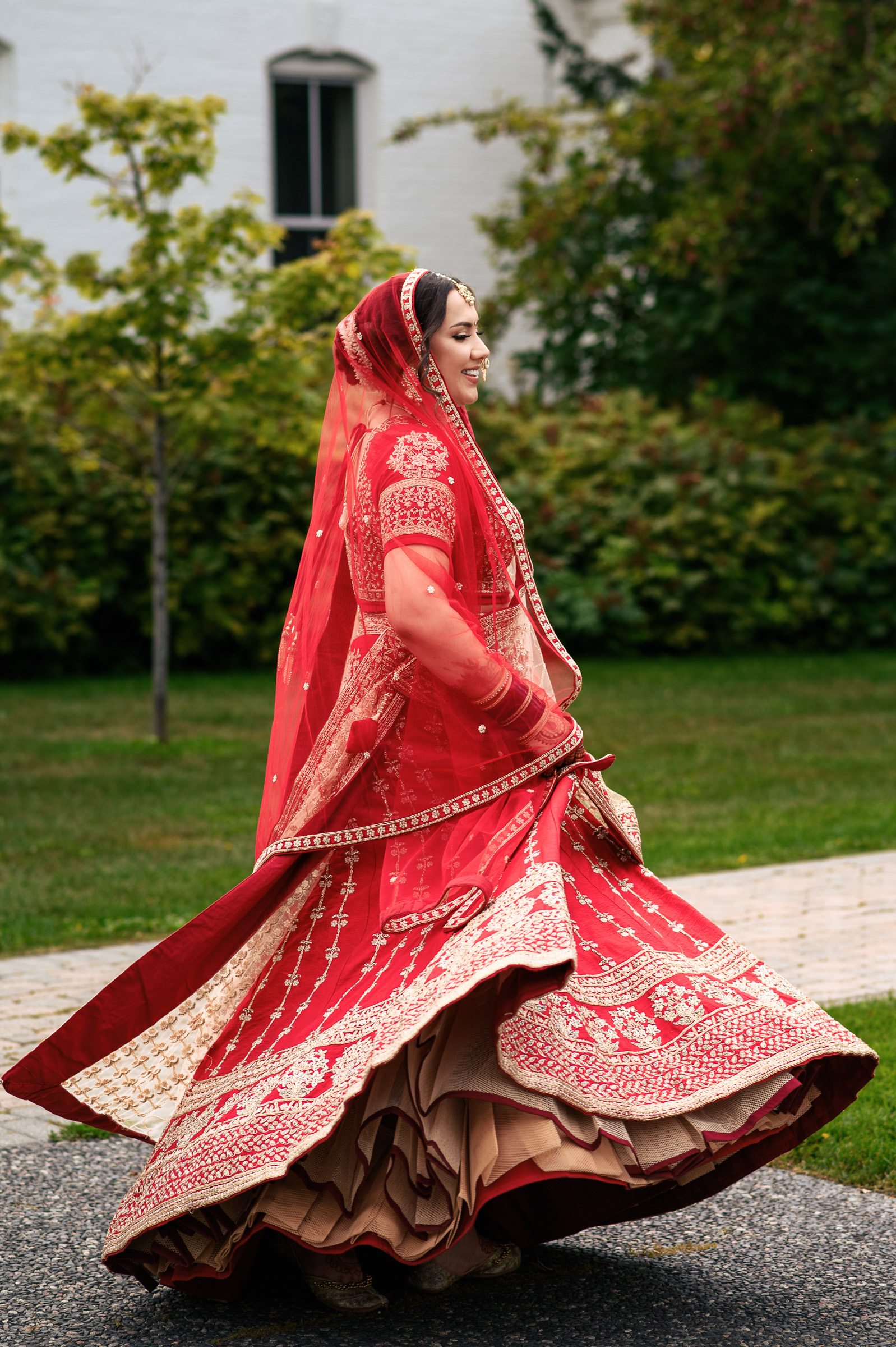 Woman in red traditional dress spinning outdoors.