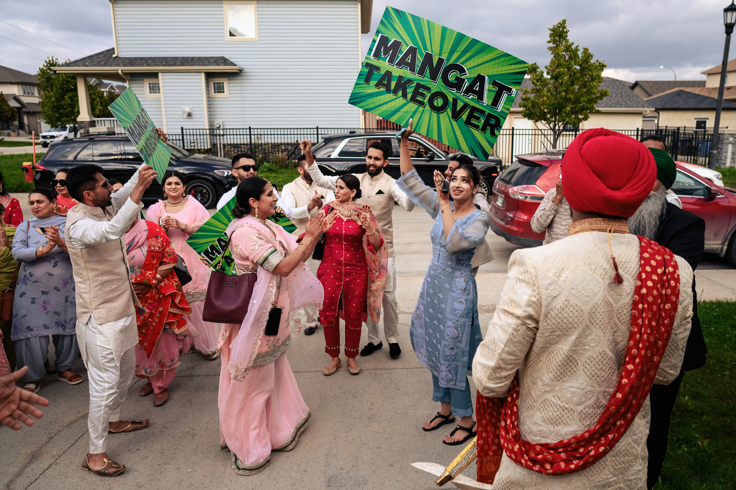Group of people celebrating outdoors with "Mangat Takeover" signs.
