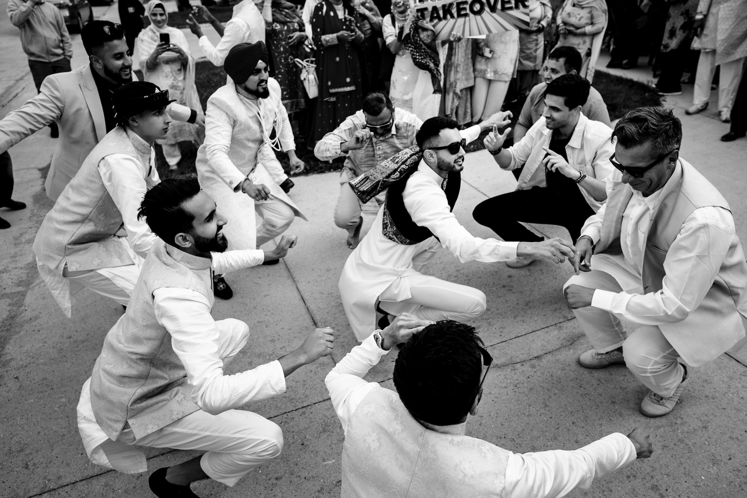 Group of people dancing energetically at an outdoor event.