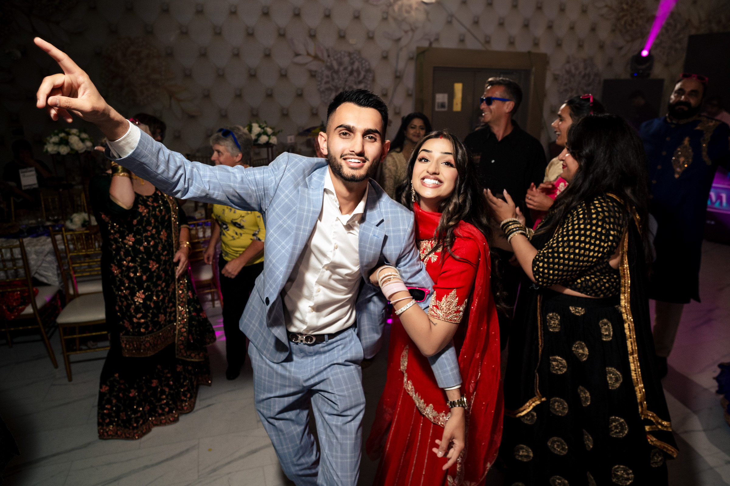 A group of people posing and dancing at a festive indoor event.