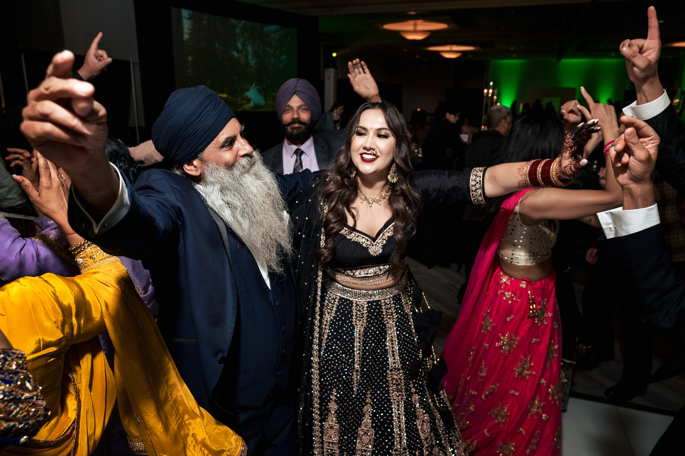 People dancing joyfully at an indoor celebration event.