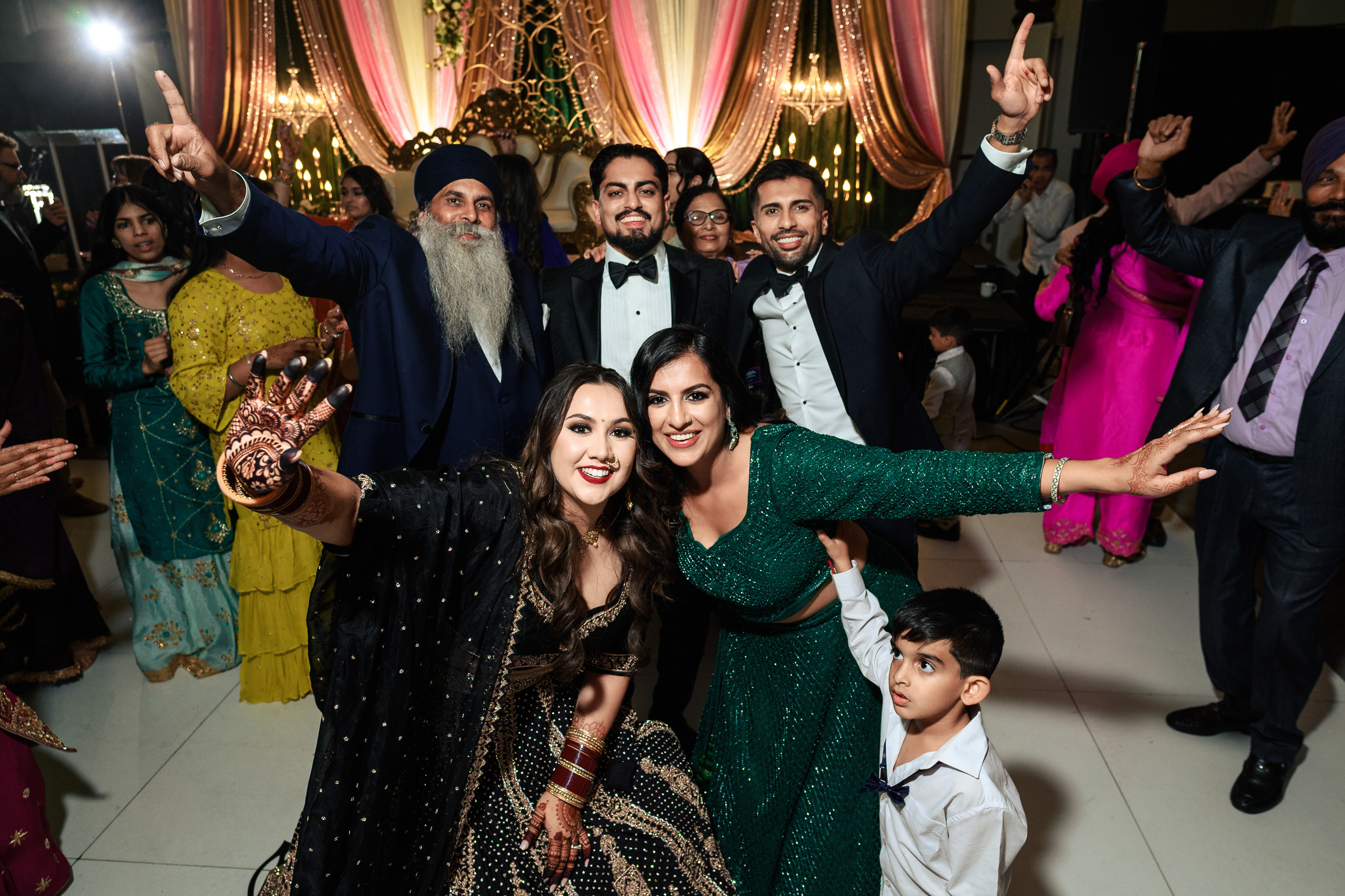 Group of people celebrating at an event with smiles and raised hands.