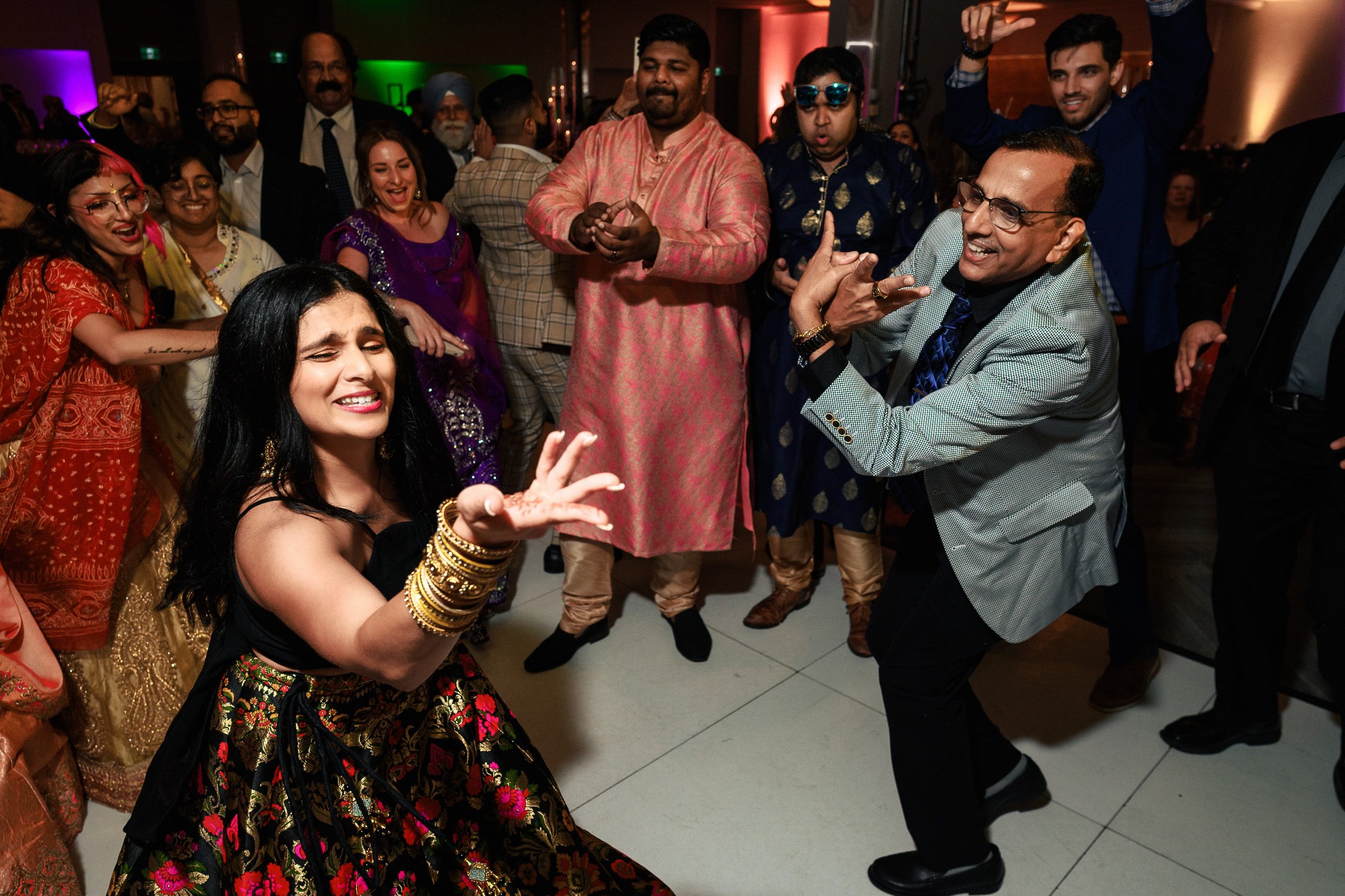 Group of people dancing energetically at a lively indoor event.