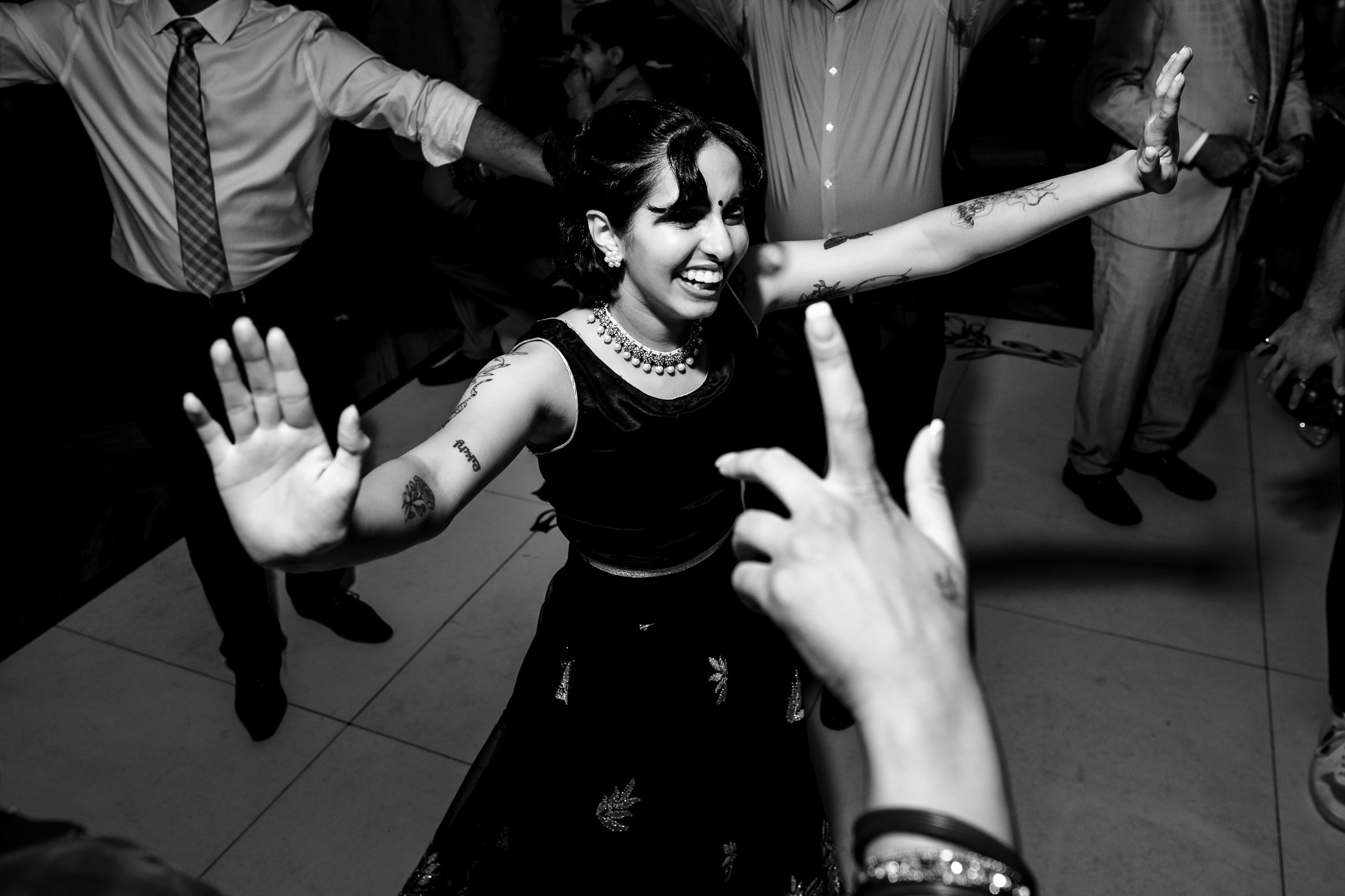 Woman dancing joyfully with others around her at a party.
