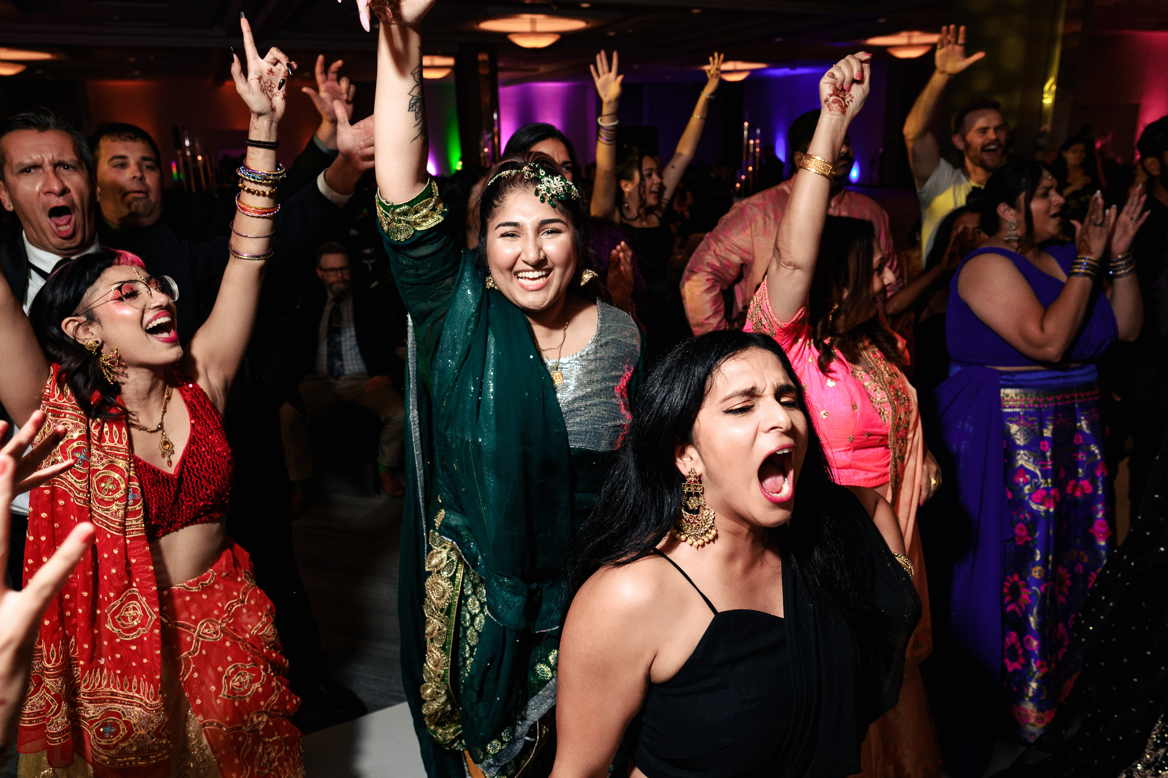 A group of people dancing energetically at a vibrant celebration or party.