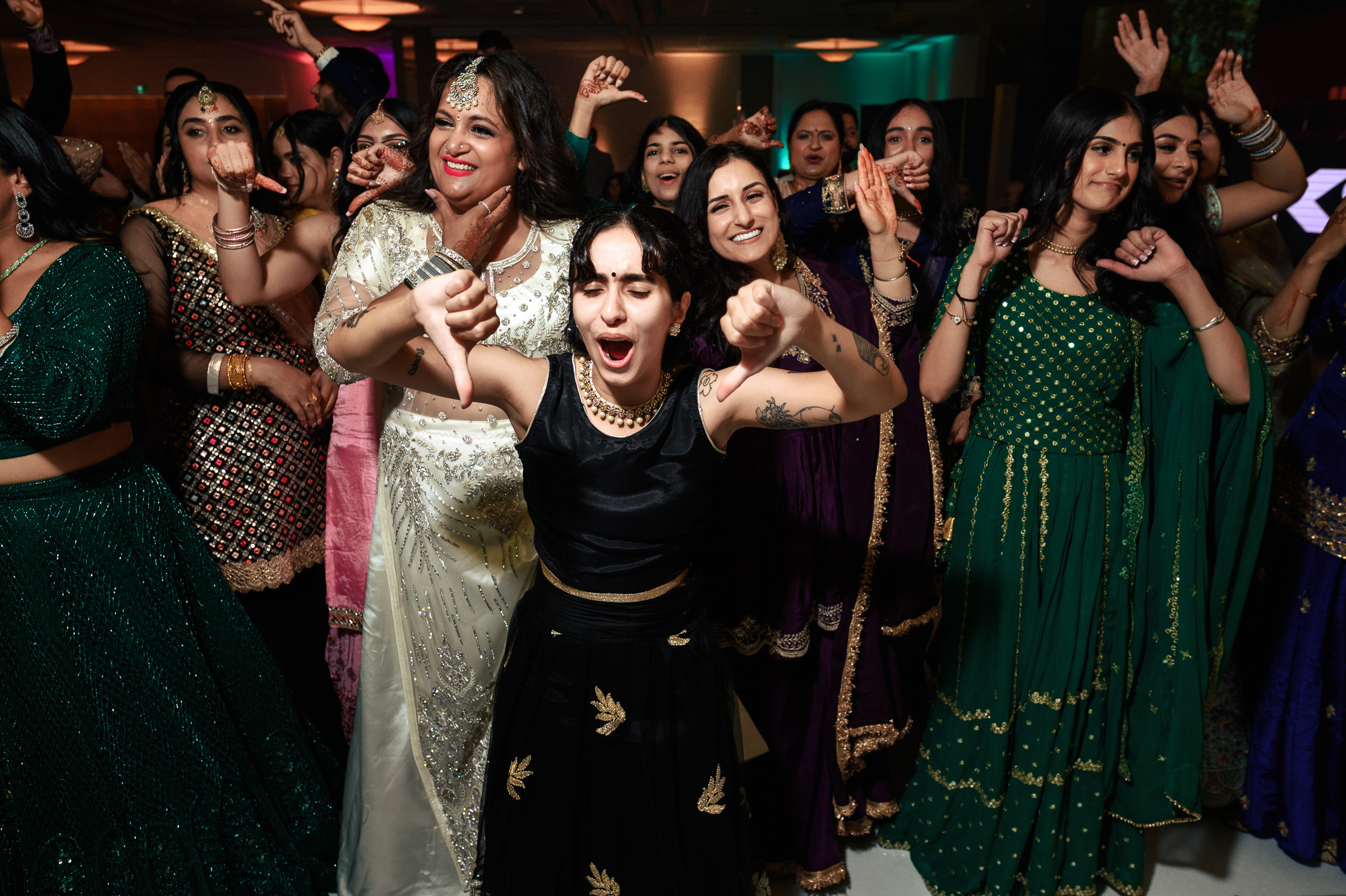 A group of women in colorful traditional attire dancing and celebrating together.