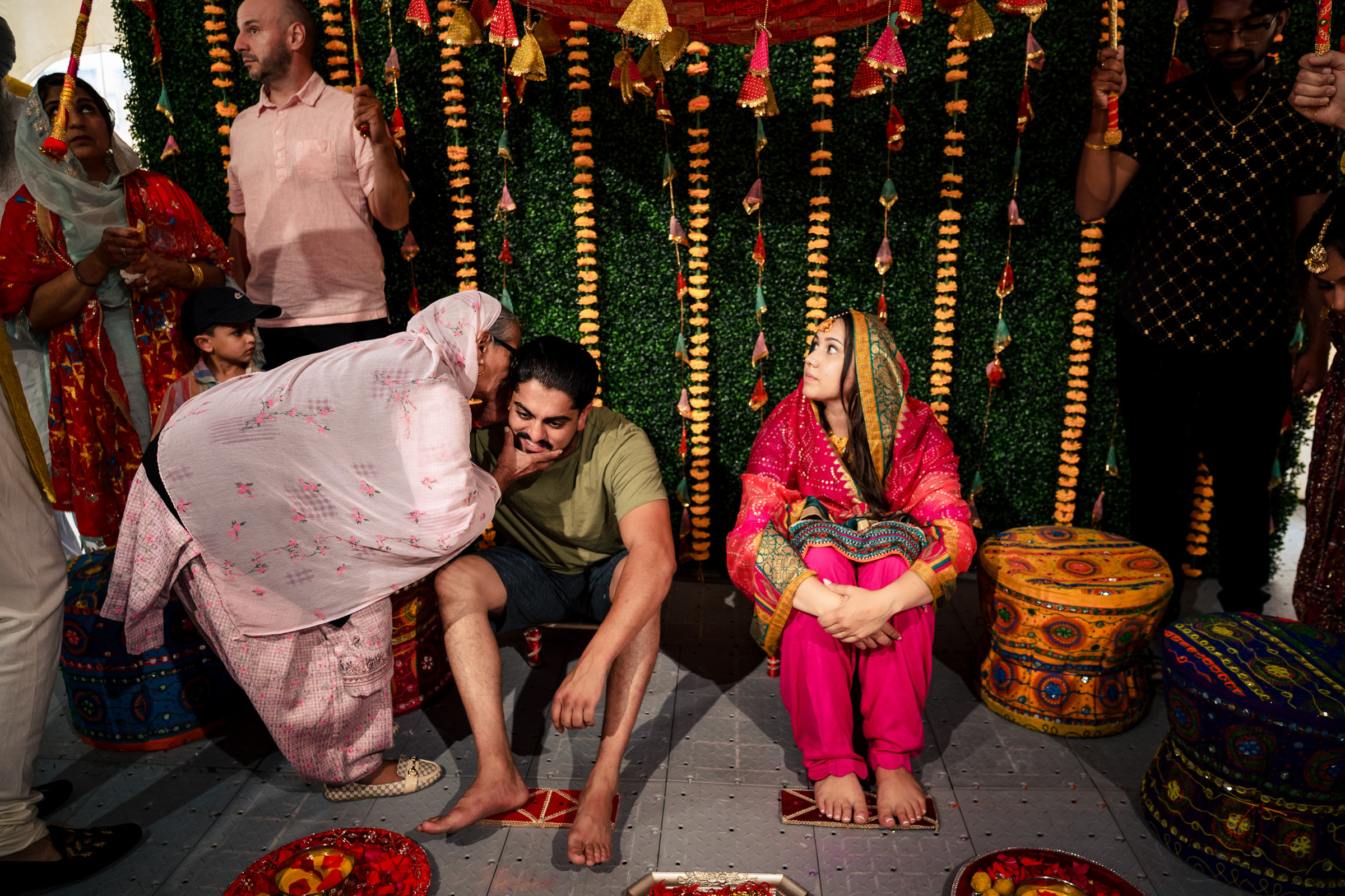 People gathered at a cultural ceremony with colorful decorations and traditional attire.