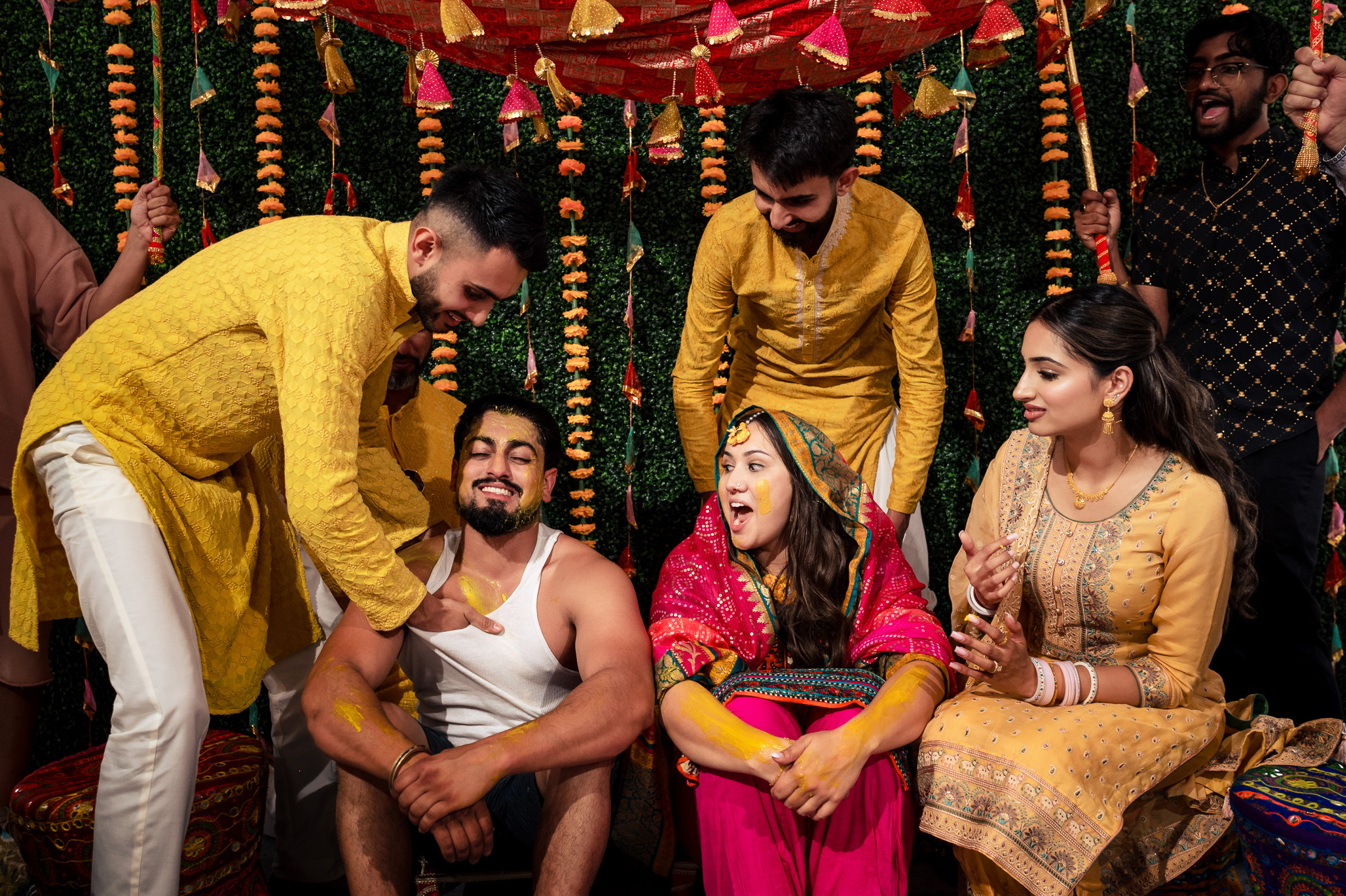 People celebrating a vibrant traditional ceremony with colorful outfits and decorations.
