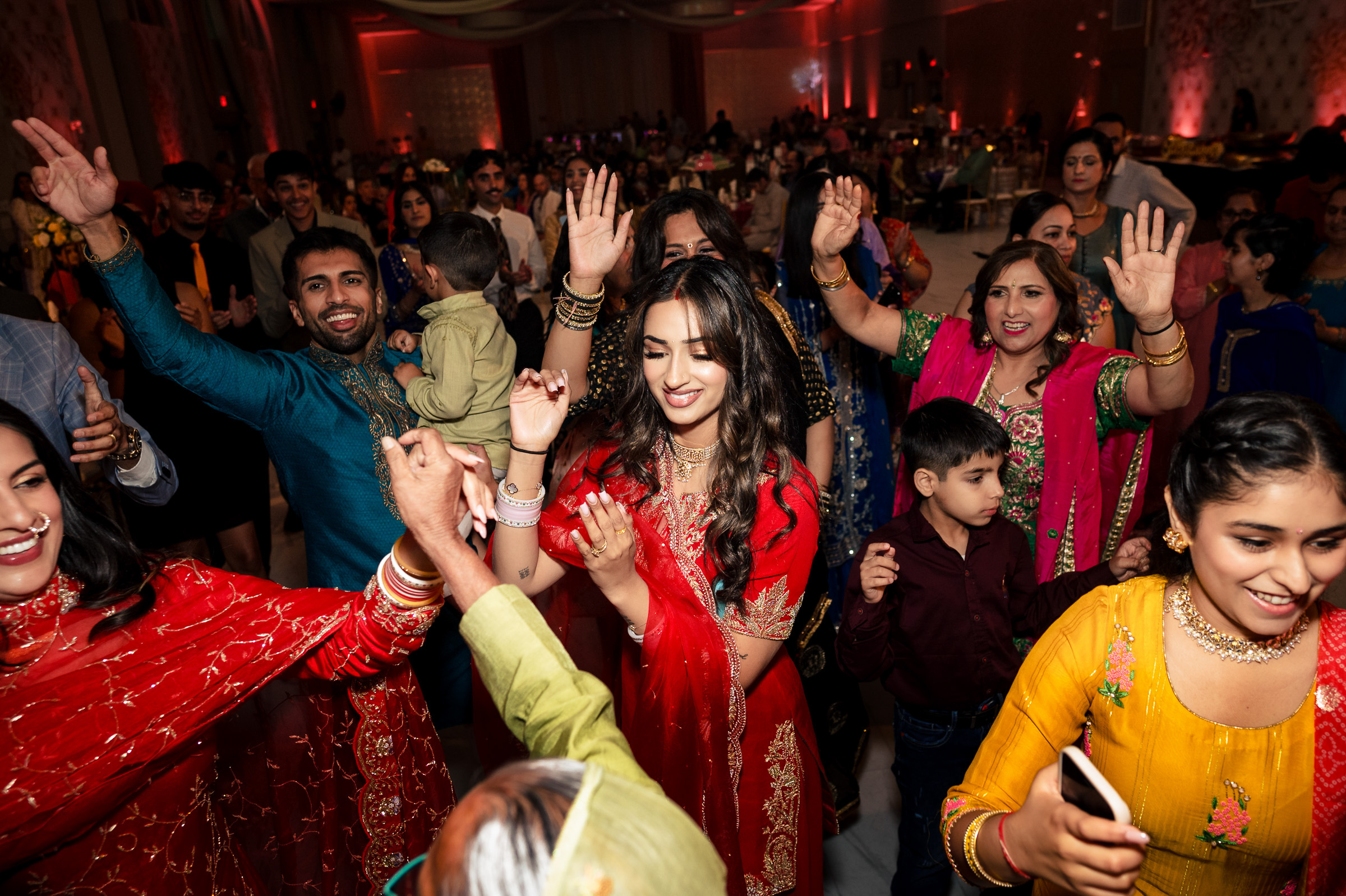 People dancing joyfully at a colorful, festive indoor event.