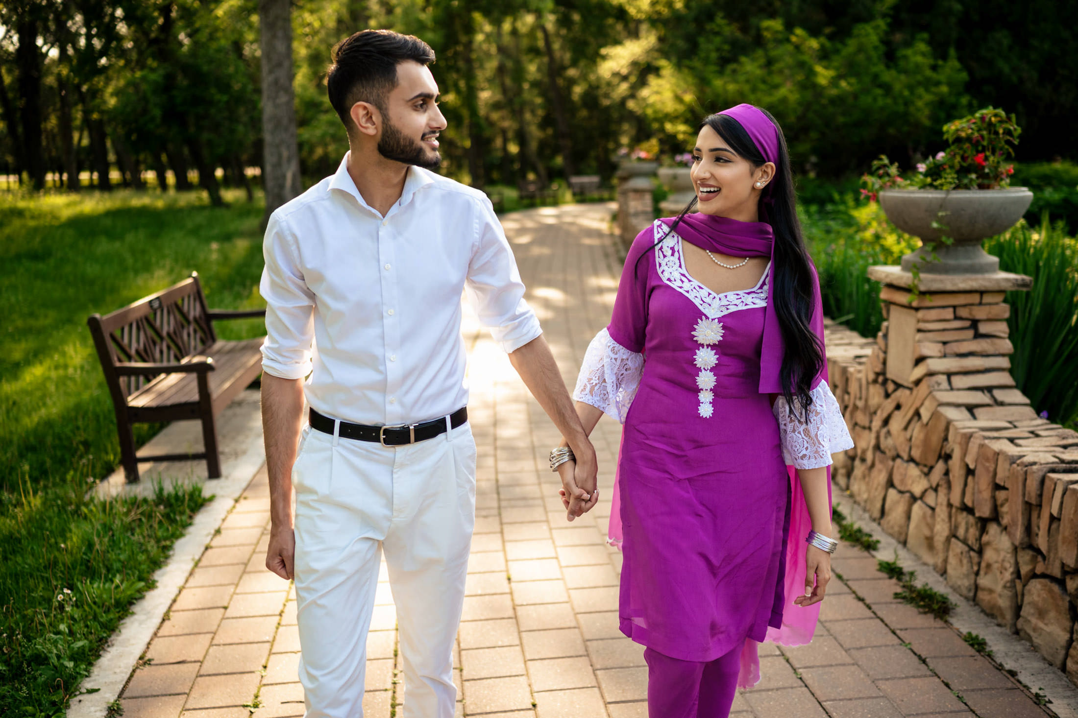 A couple strolls on a park pathway, sharing smiles and a quiet engagement at home.