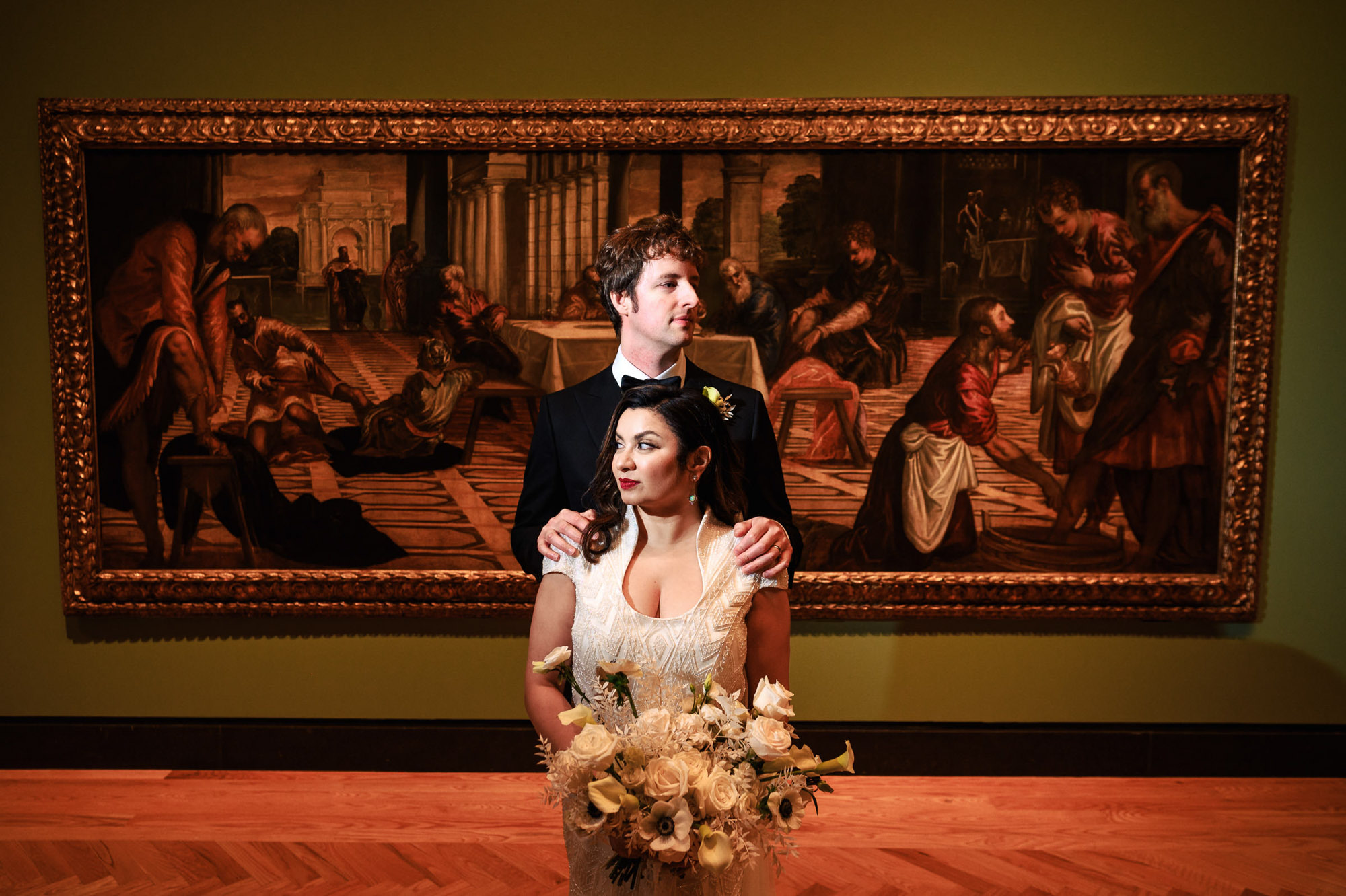 Couple at Art Gallery of Ontario, bride holds a bouquet of white flowers.