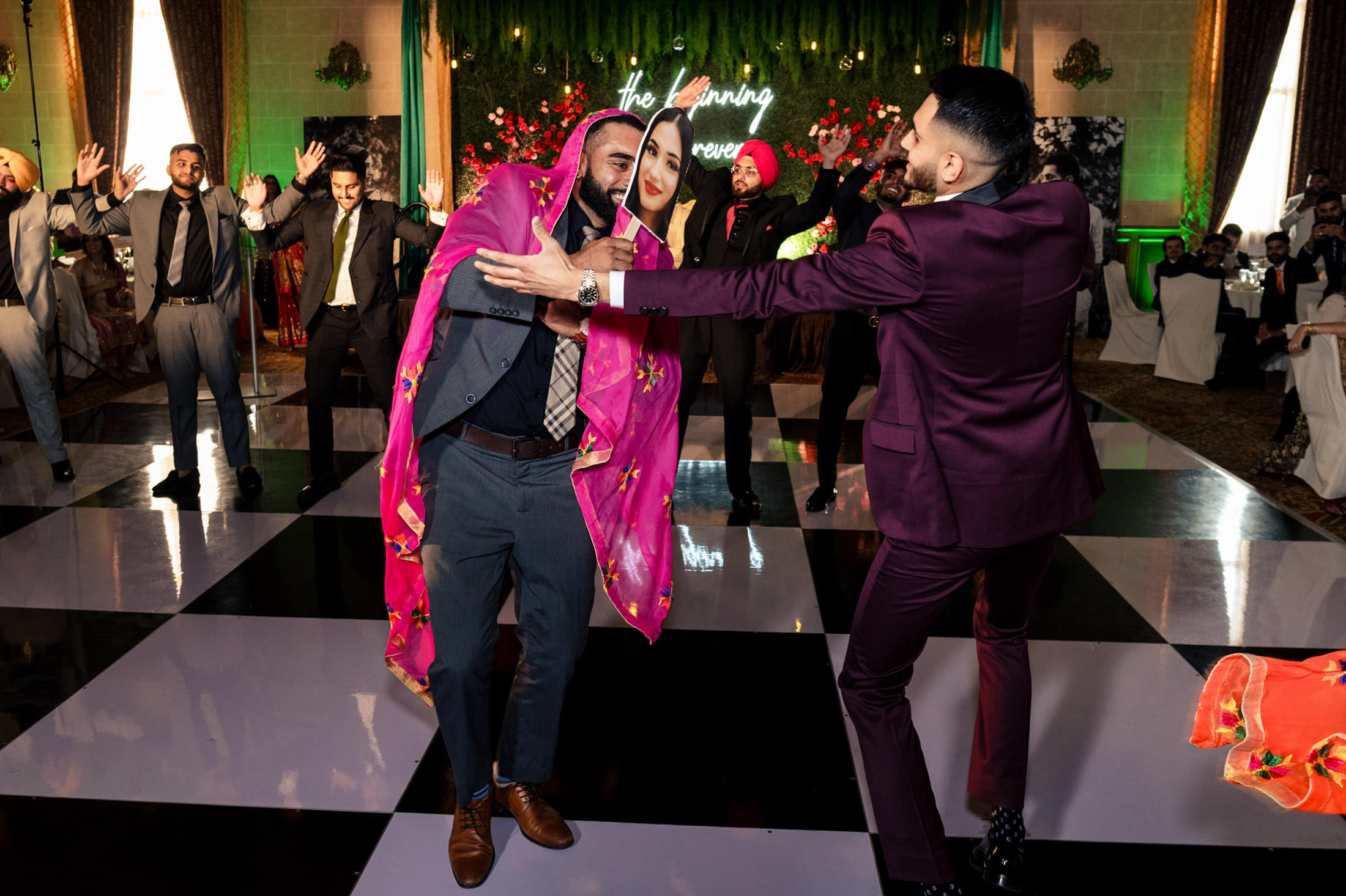 People dancing energetically on a checkered dance floor at a lively Winnipeg wedding.