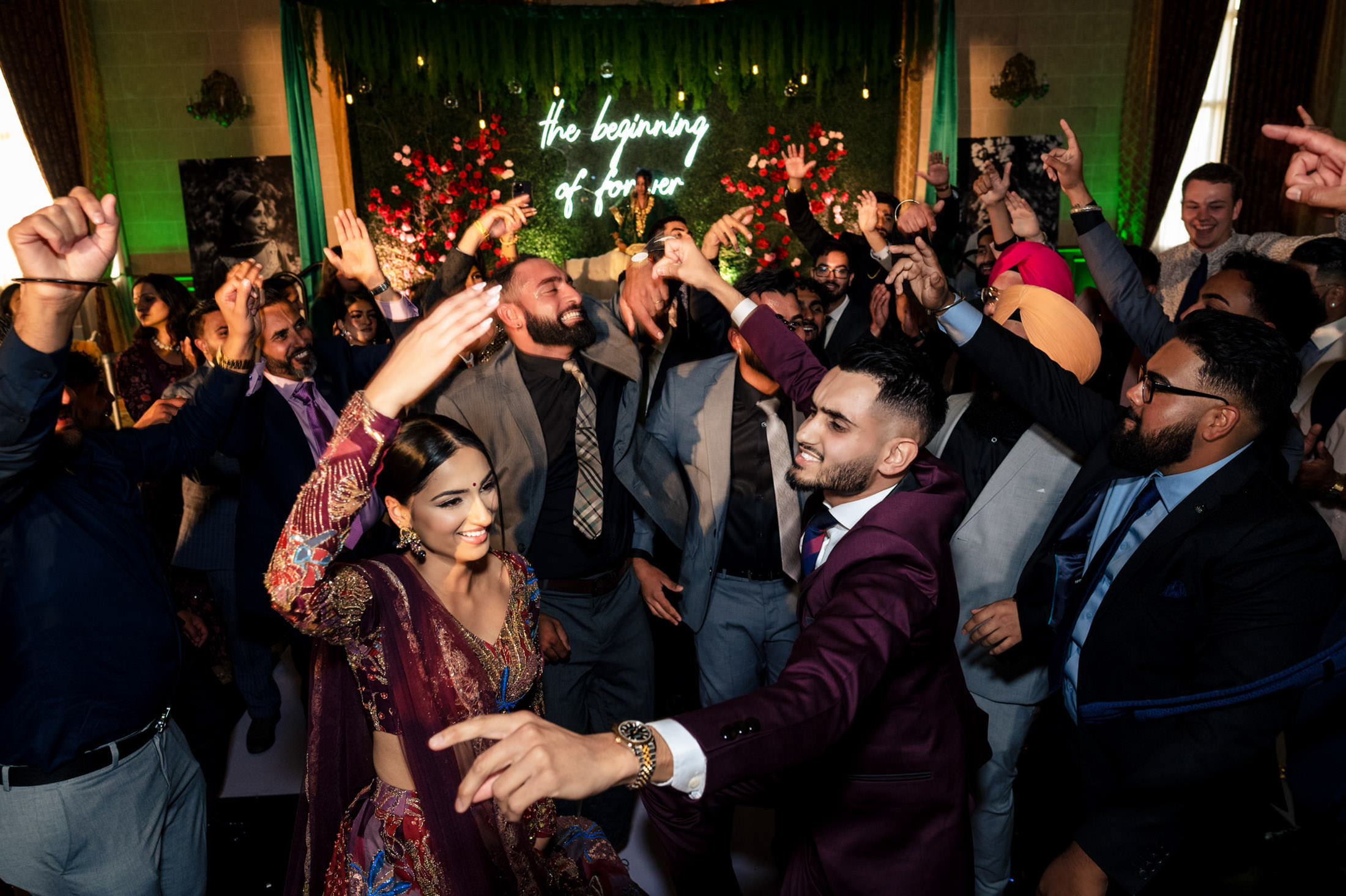 People dancing energetically at a lively Winnipeg wedding with festive lights and decorations.